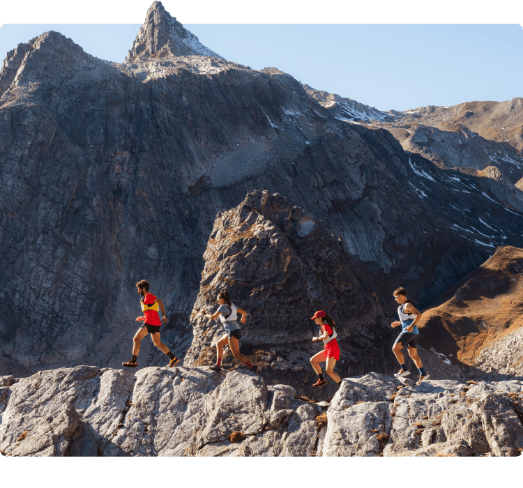 A group of mountain runners traversing a jagged, sun-drenched alpine ridgeline in La Sportiva high-performance mountain running gear.