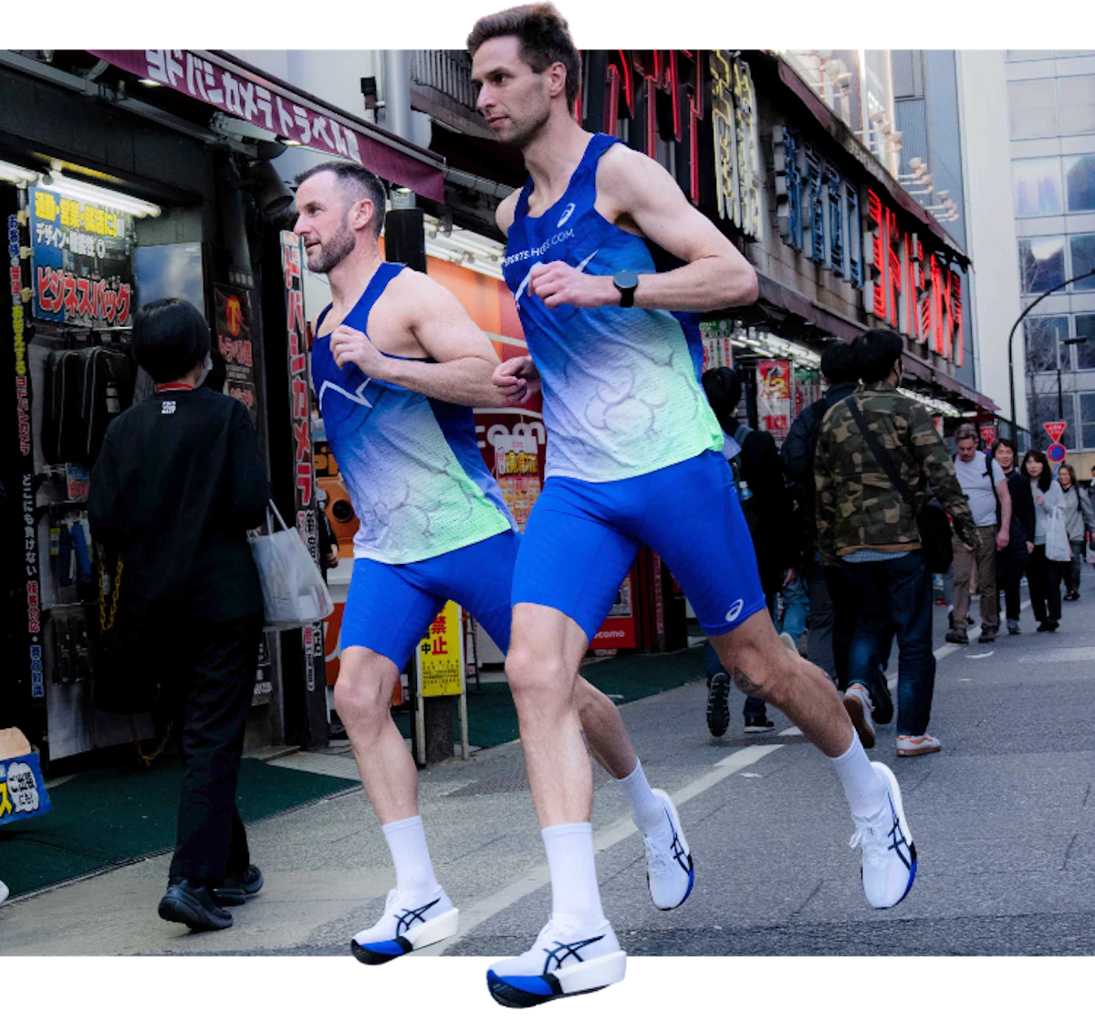 Elite runners Simon Smith and David Gärtlein sprinting through the streets of Tokyo during the 2026 Tokyo Marathon event, wearing the limited edition ASICS METASPEED Sky Tokyo and Edge Paris carbon-plated racing shoes in vibrant blue and white.