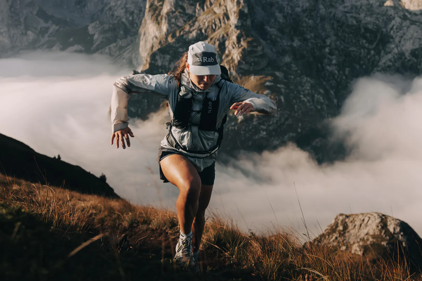 Woman in jacket running up a mountain