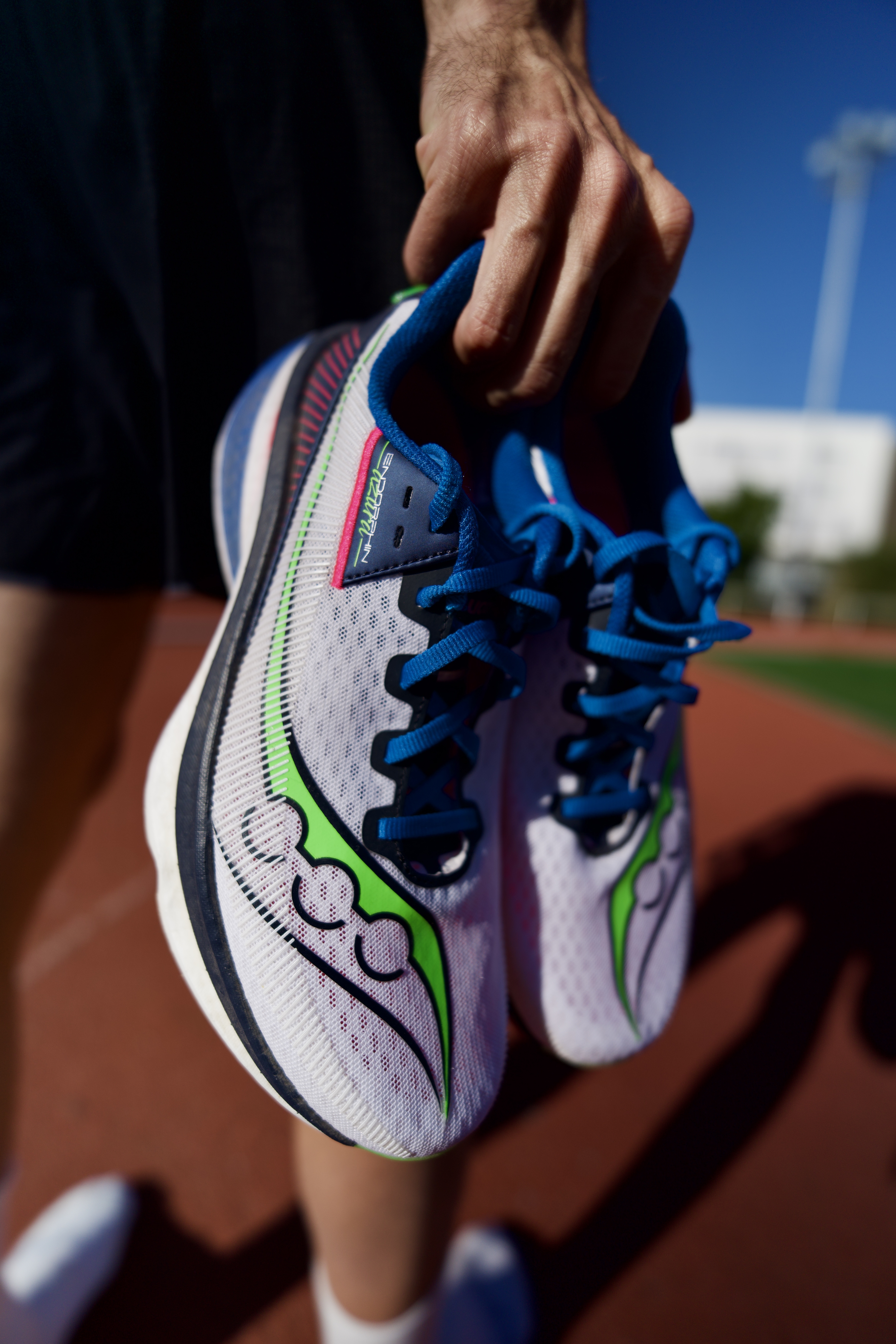 hands-holding-pair-of-saucony-endorphin-azura-running-shoes