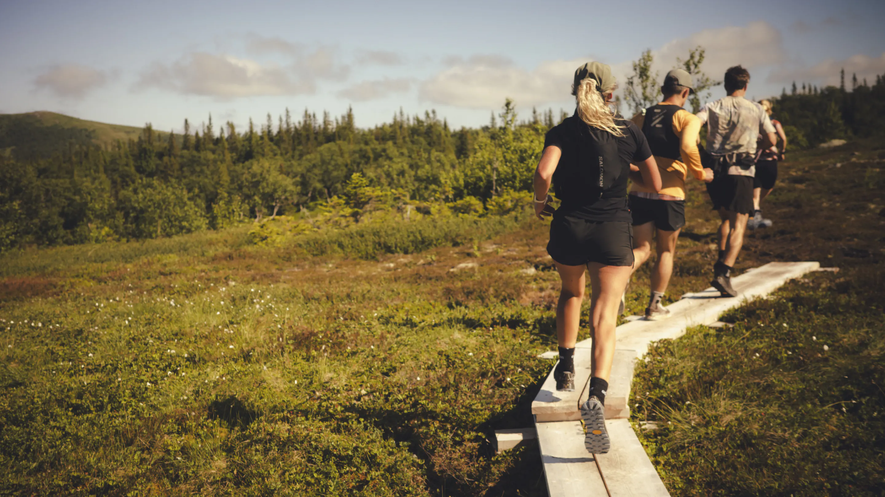 Kilian Jornet Foundation volenteers running across traditional Swedish wooden boardwalks