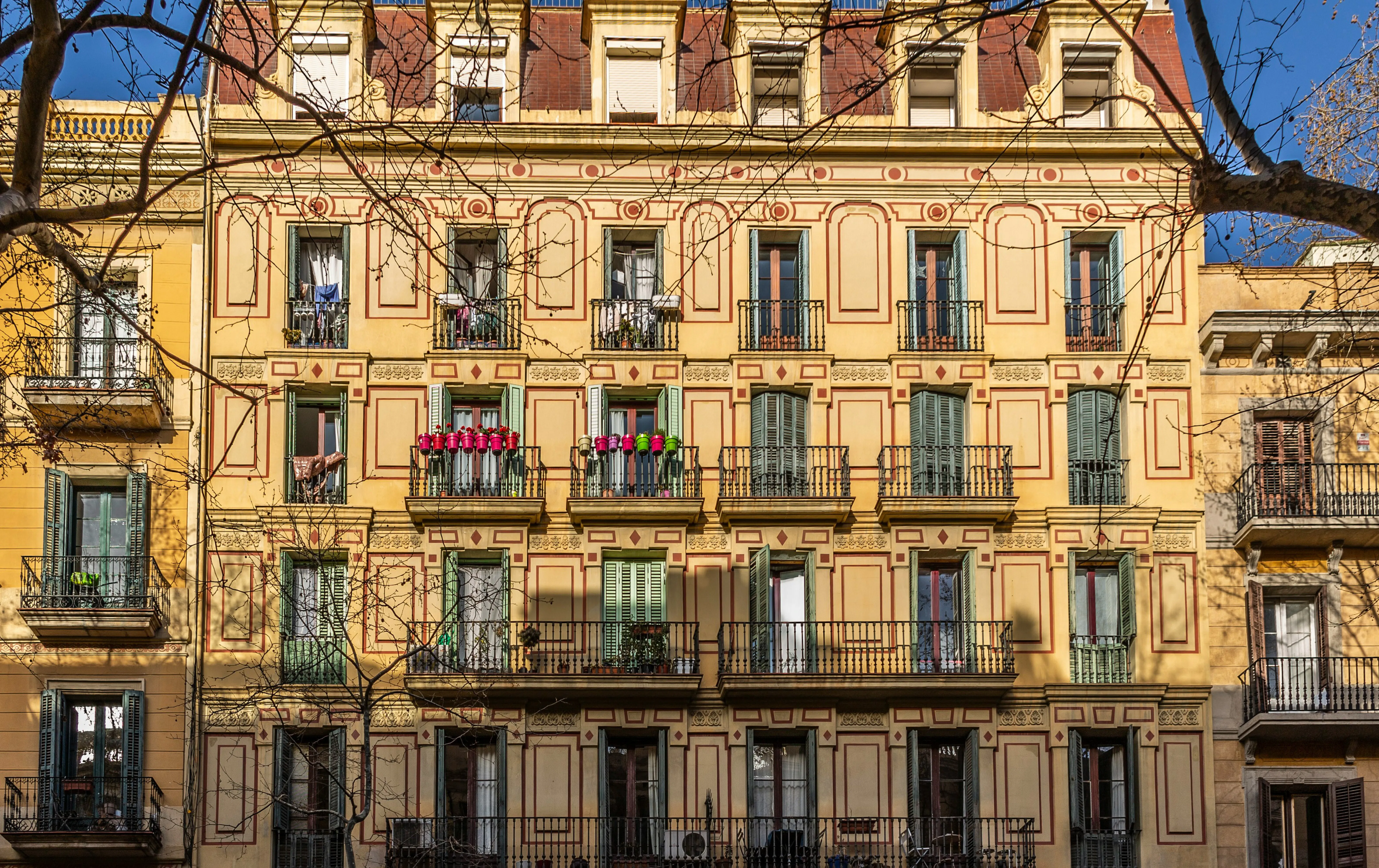 Traditional apartment building in Barcelona with ornate balconies and several residential floors, illustrating the different apartment levels found in the city.
