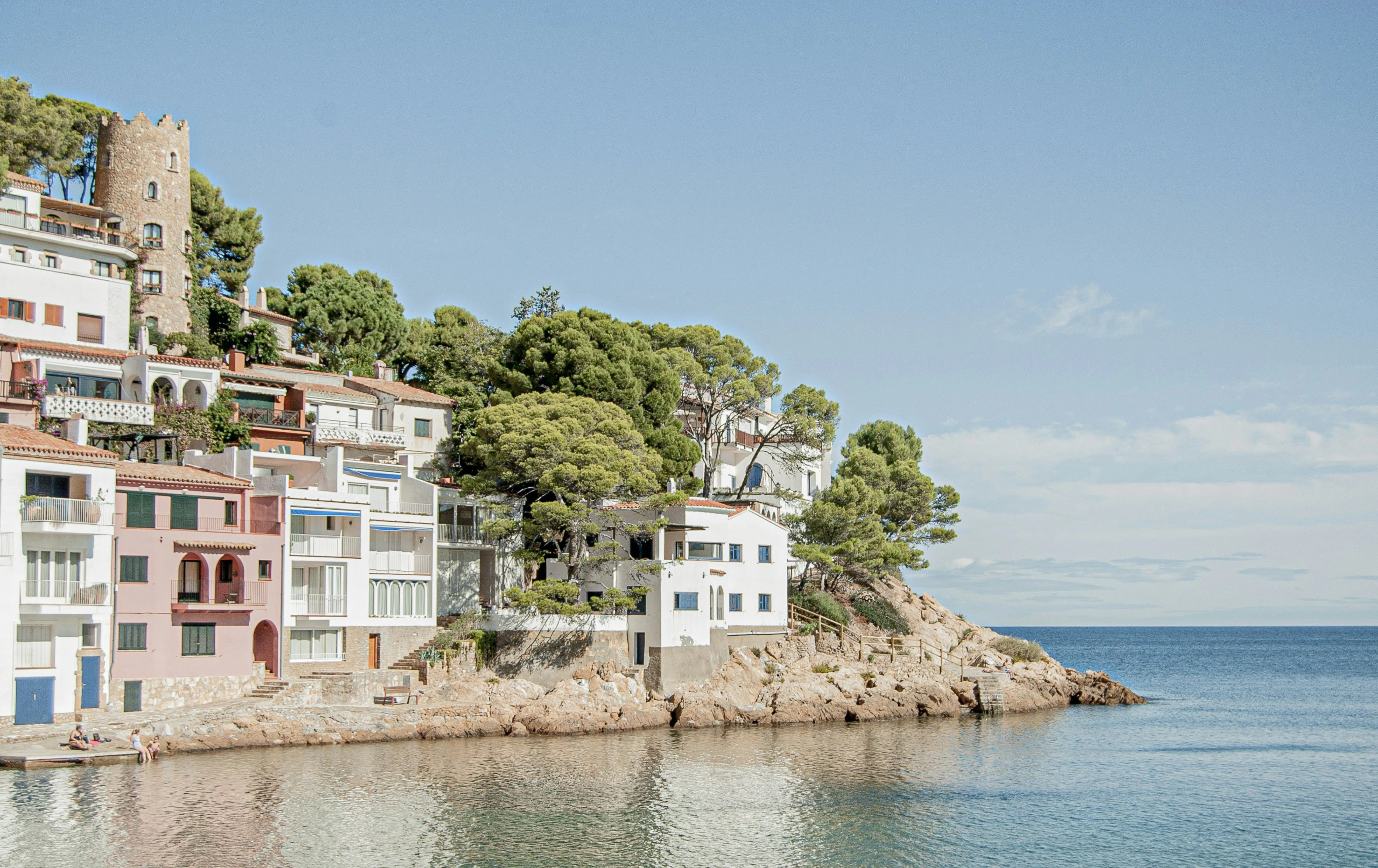 Küstenhäuser in Katalonien mit Blick auf das Mittelmeer als Beispiel für die Attraktivität von Barcelona, Girona und Tarragona für internationale Immobilienkäufer.