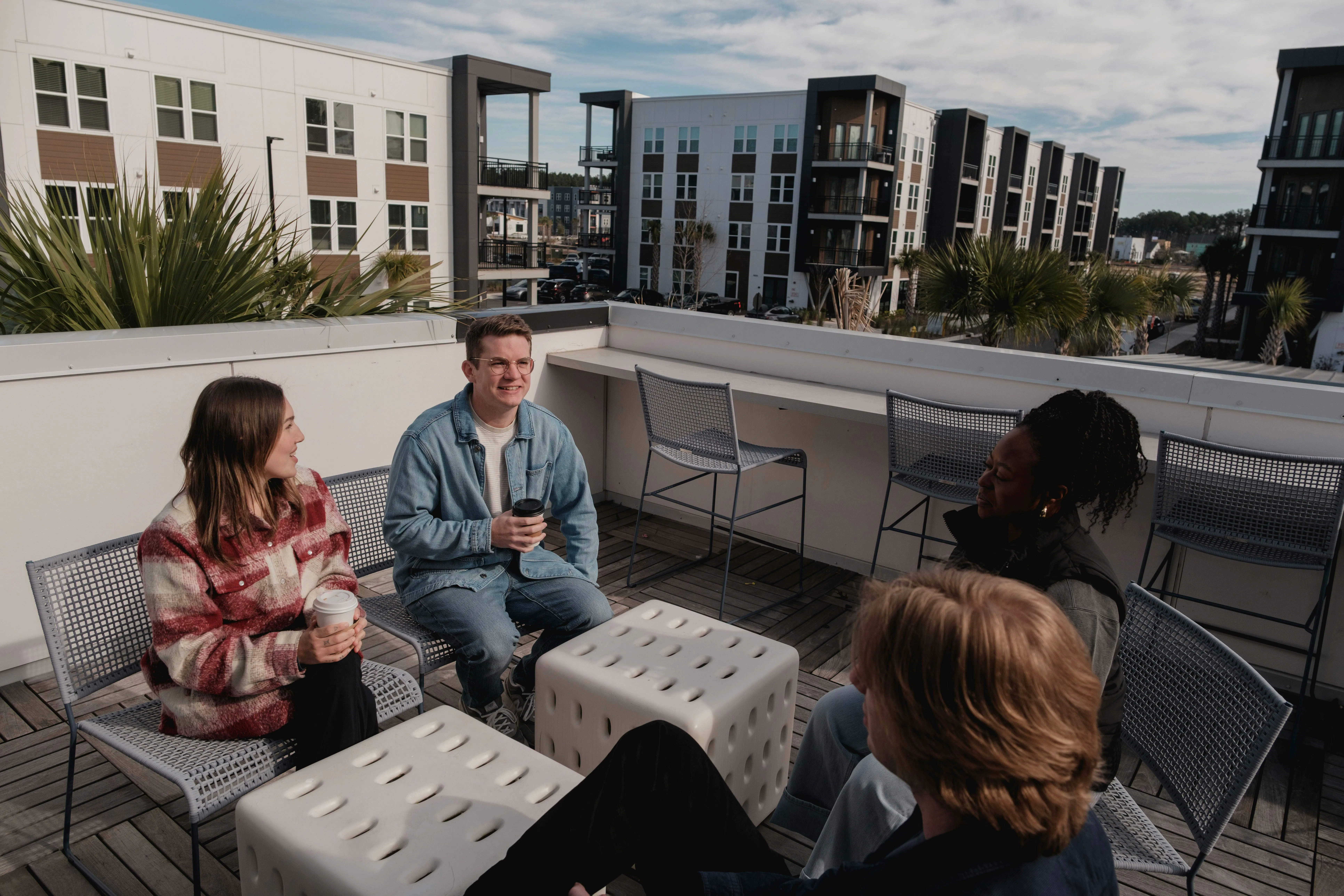 Un grupo de jóvenes sentados en una terraza en España, representando al colectivo afectado por la falta de acceso a la vivienda y el bajo alcance del Bono Alquiler Joven 2026.