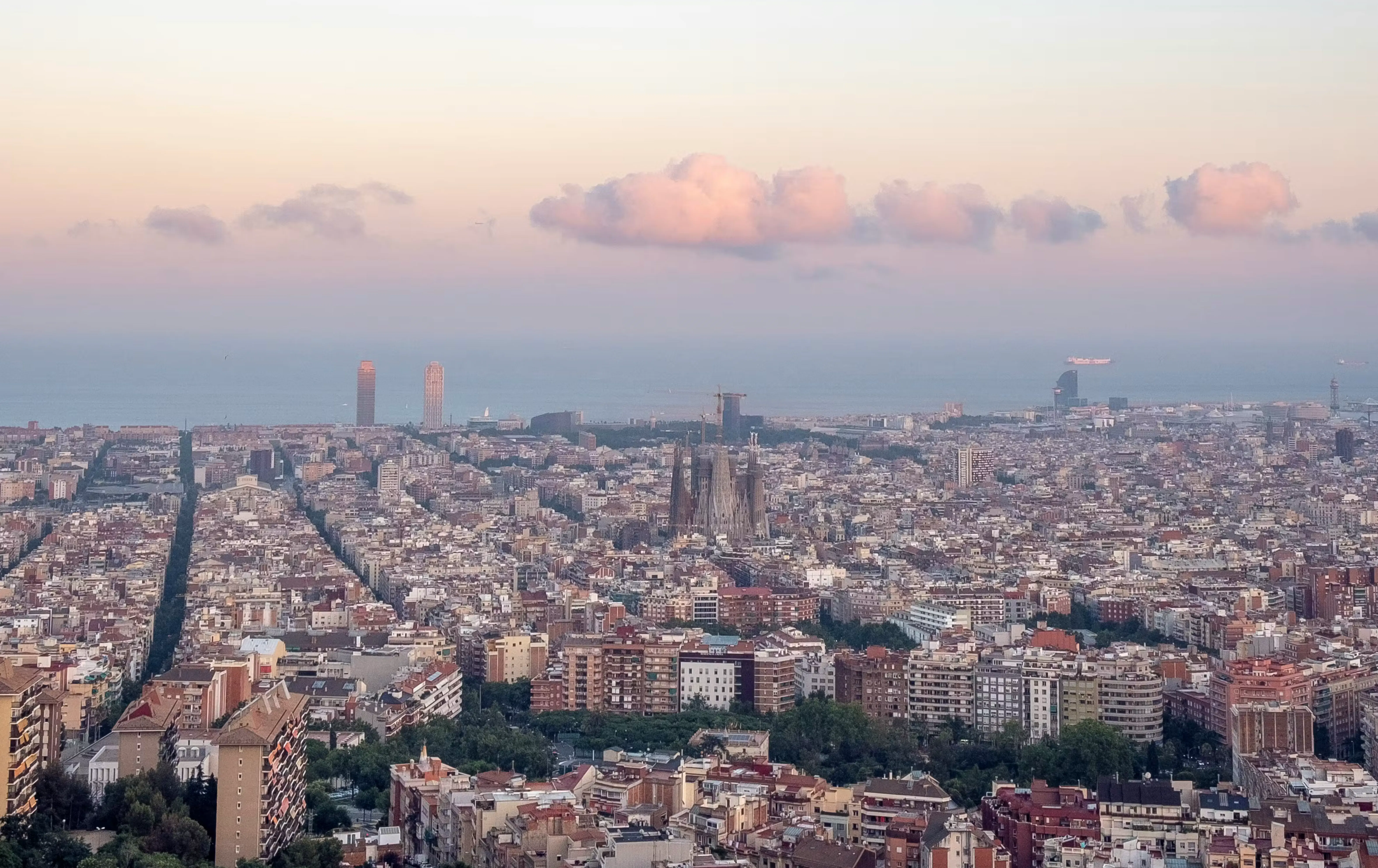 Panoramic view of Barcelona residential real estate and housing markets at sunset, overlooking Eixample districts.