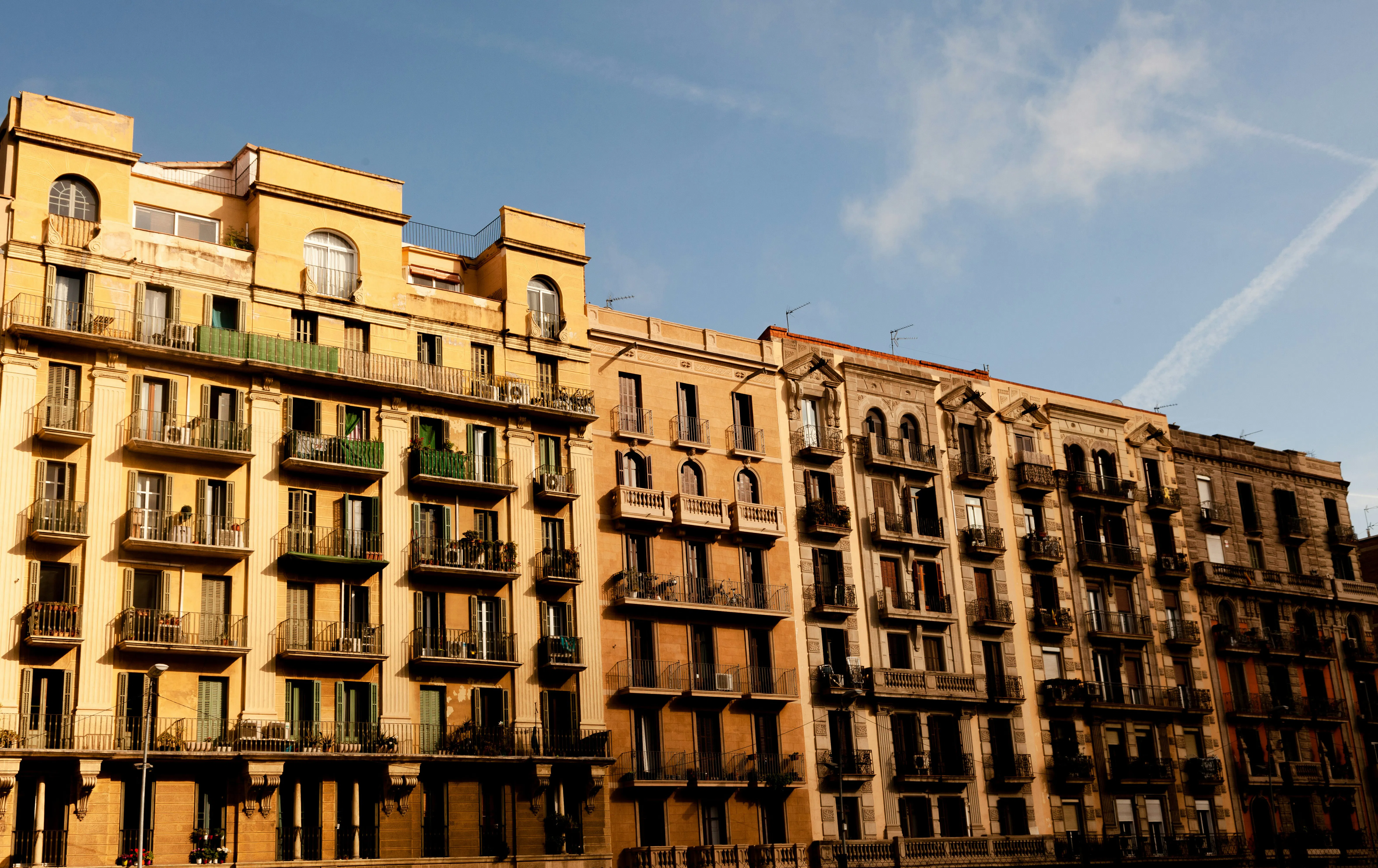 Carrer residencial de Barcelona amb edificis d’habitatges, que representa el mercat immobiliari de la ciutat i la comparació entre el poder adquisitiu local i internacional.