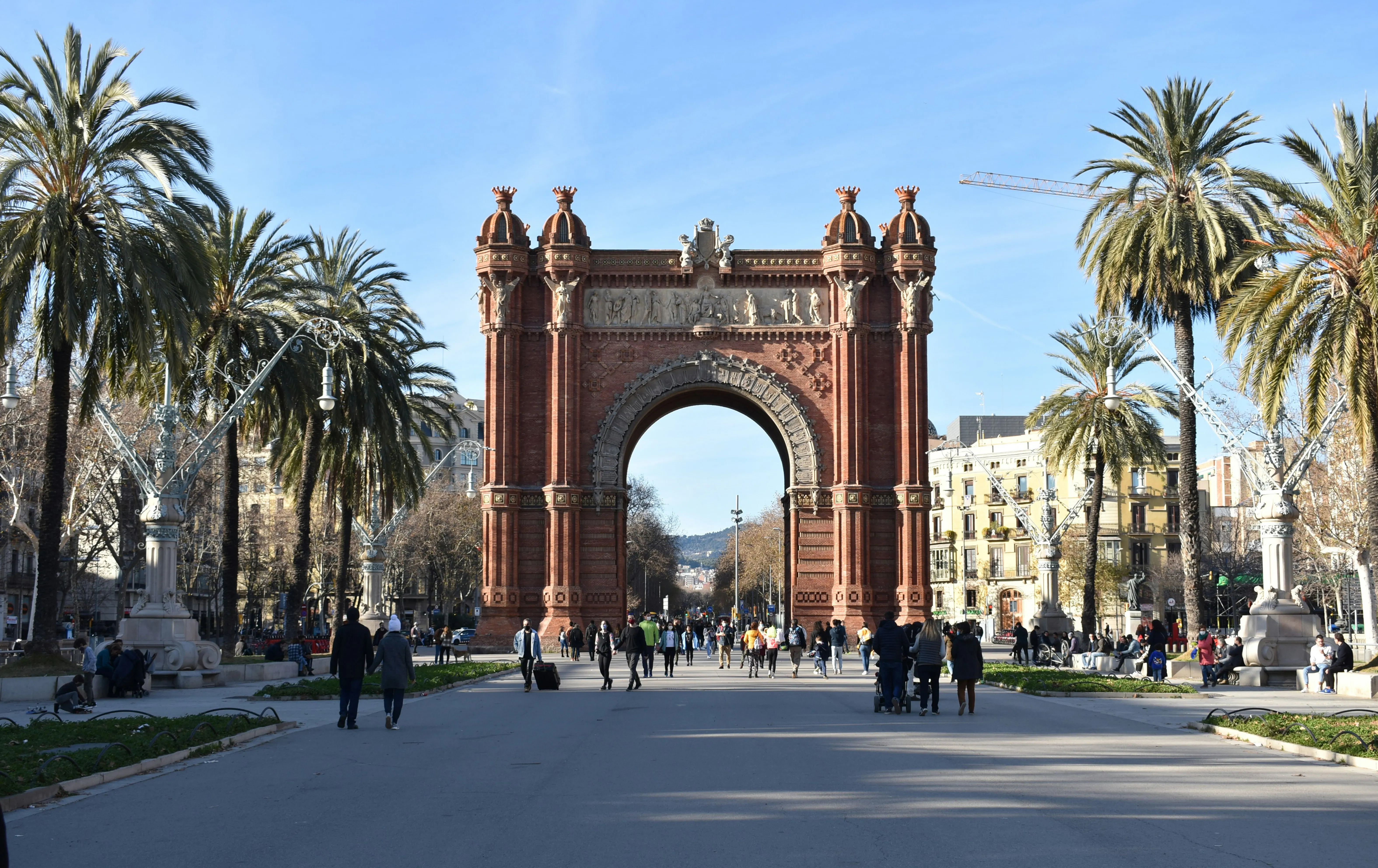 Der Arc de Triomf in Barcelona, eingerahmt von Palmen entlang des Passeig de Lluís Companys.