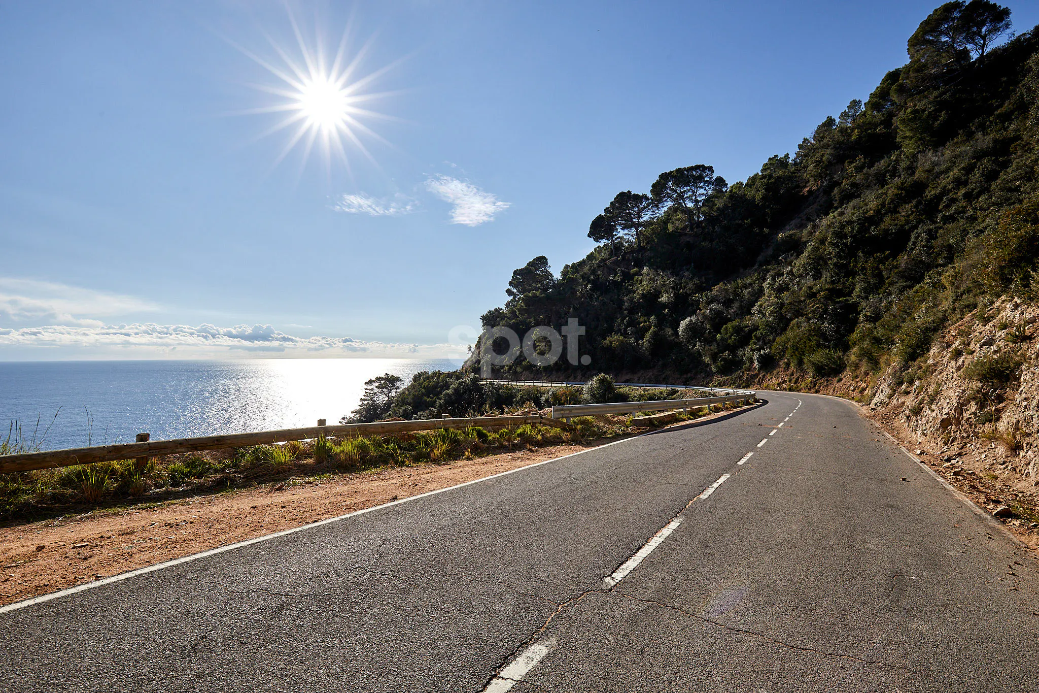 Coastal road filming location in Spain with sea views, bright sunlight, cliffs and curves for car commercials and automotive productions
