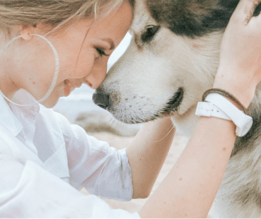 Young woman nuzzling a dog