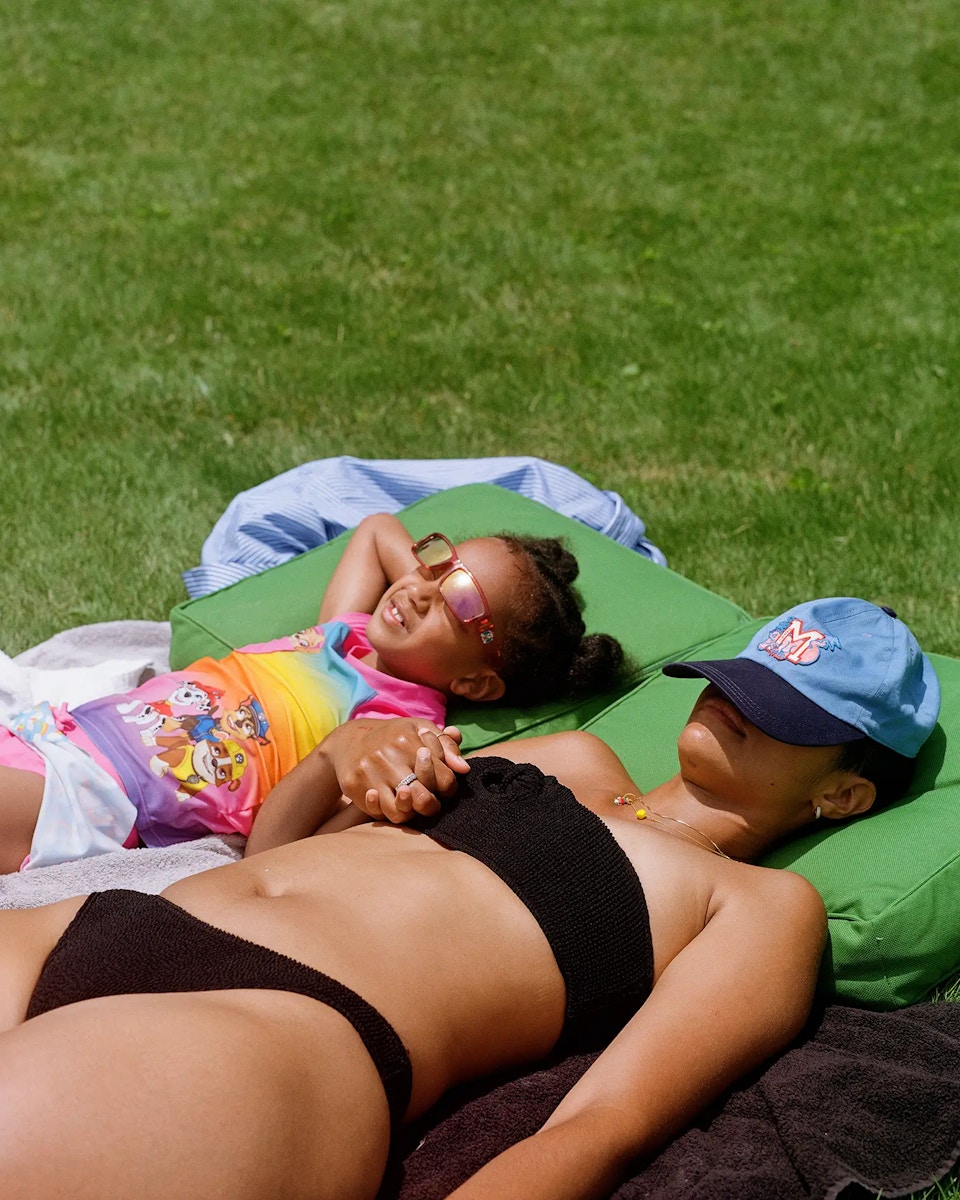 mom and daughter laying in grass sunbathing