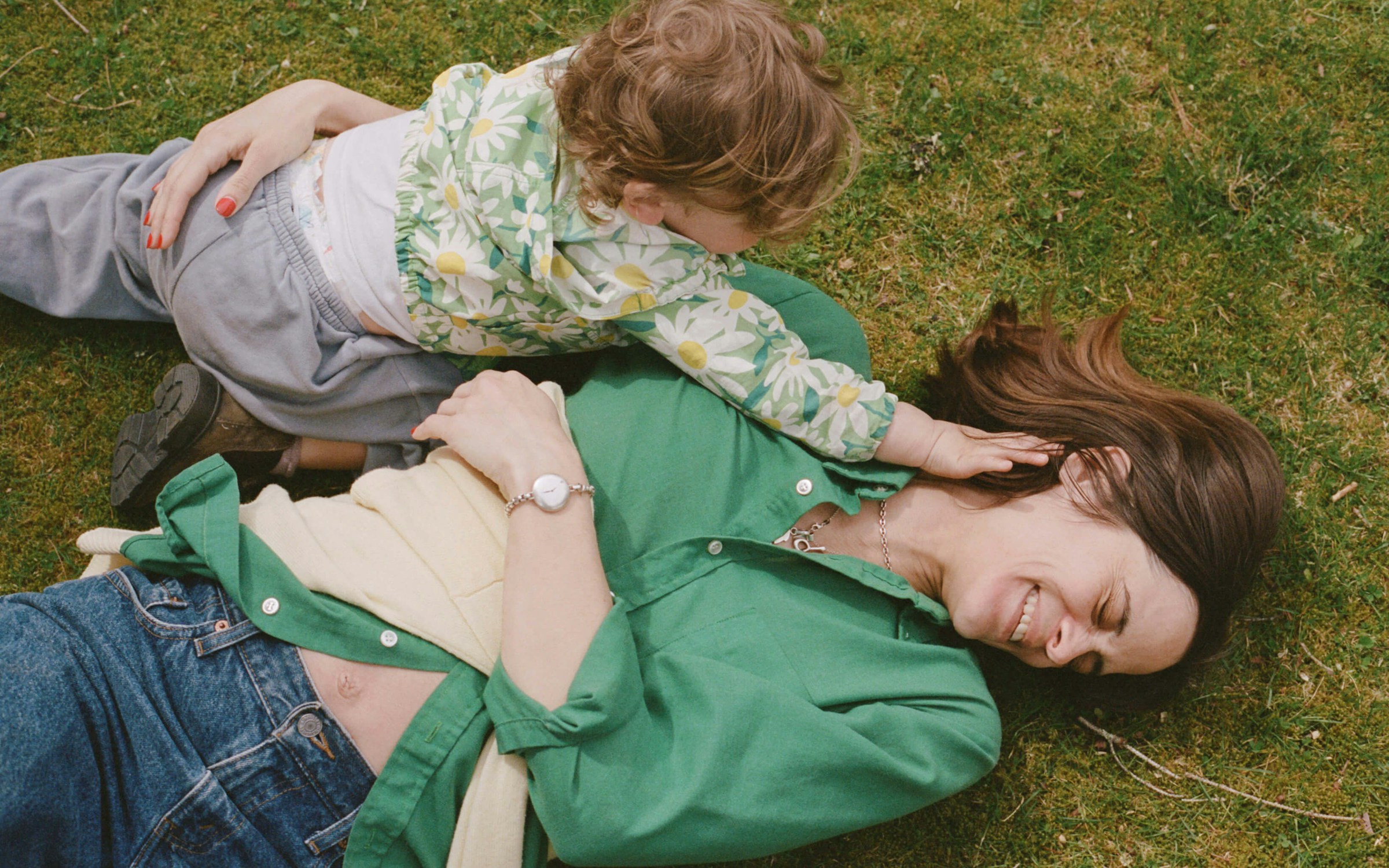 mom and son laying in the grass