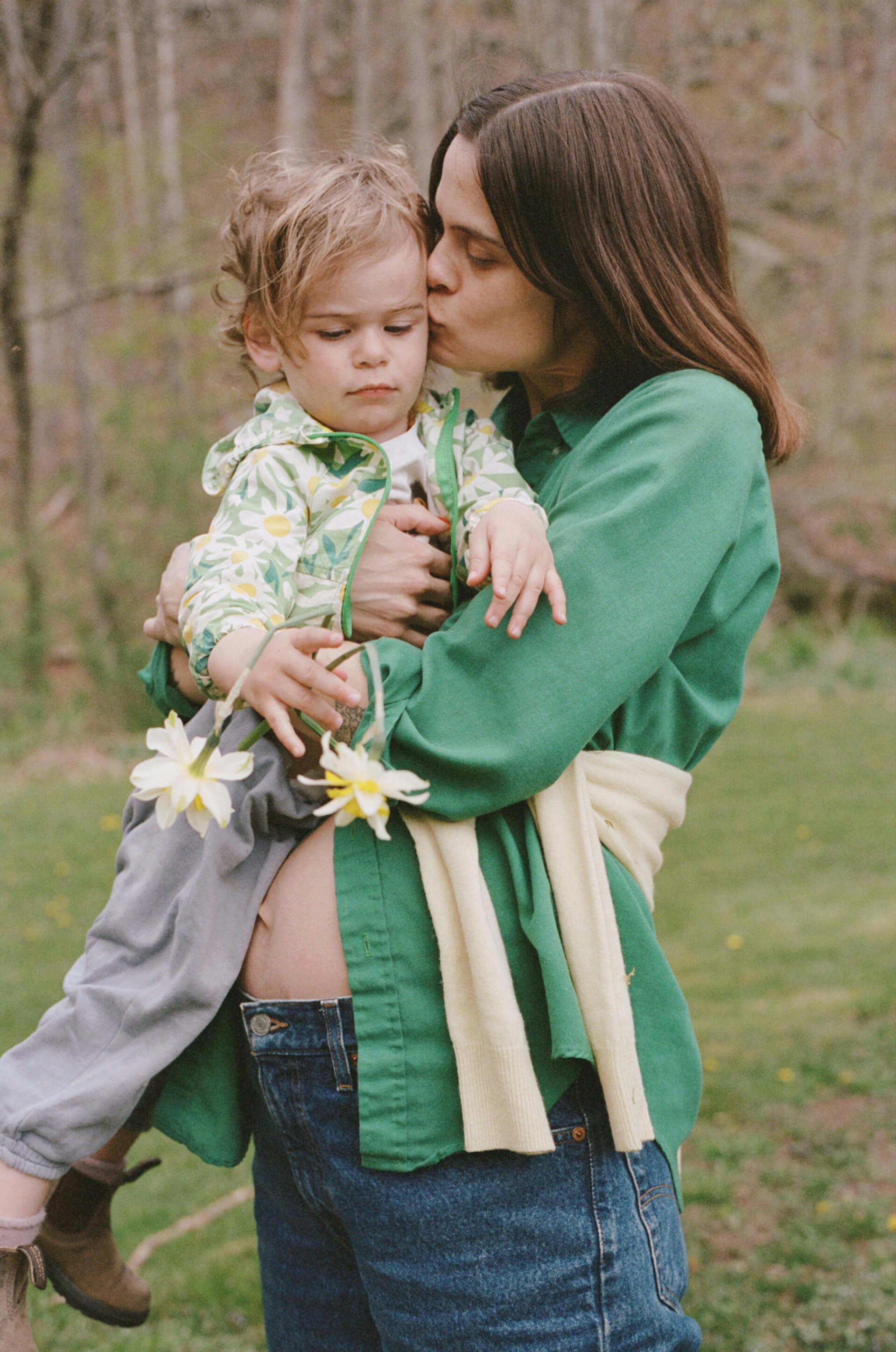 pregnant mom holding her son and kissing him on the cheek