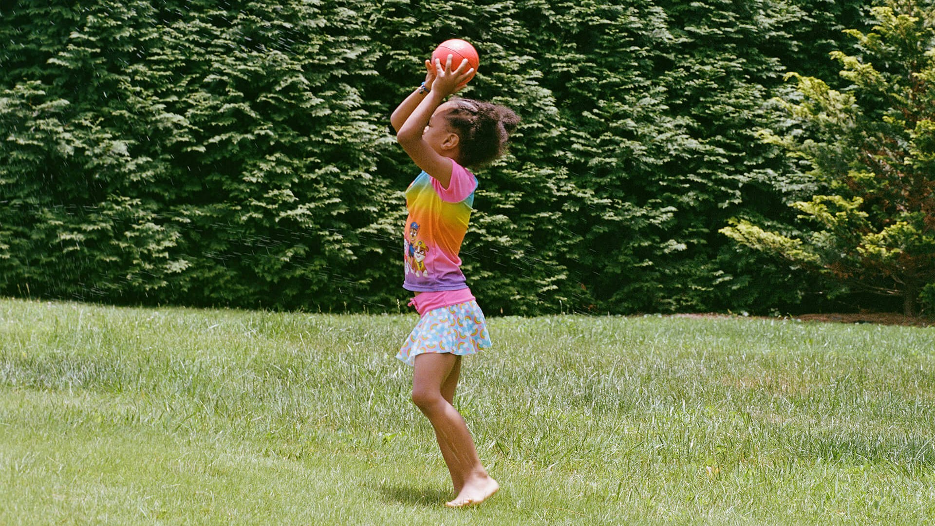 daughter playing with a ball on the grass