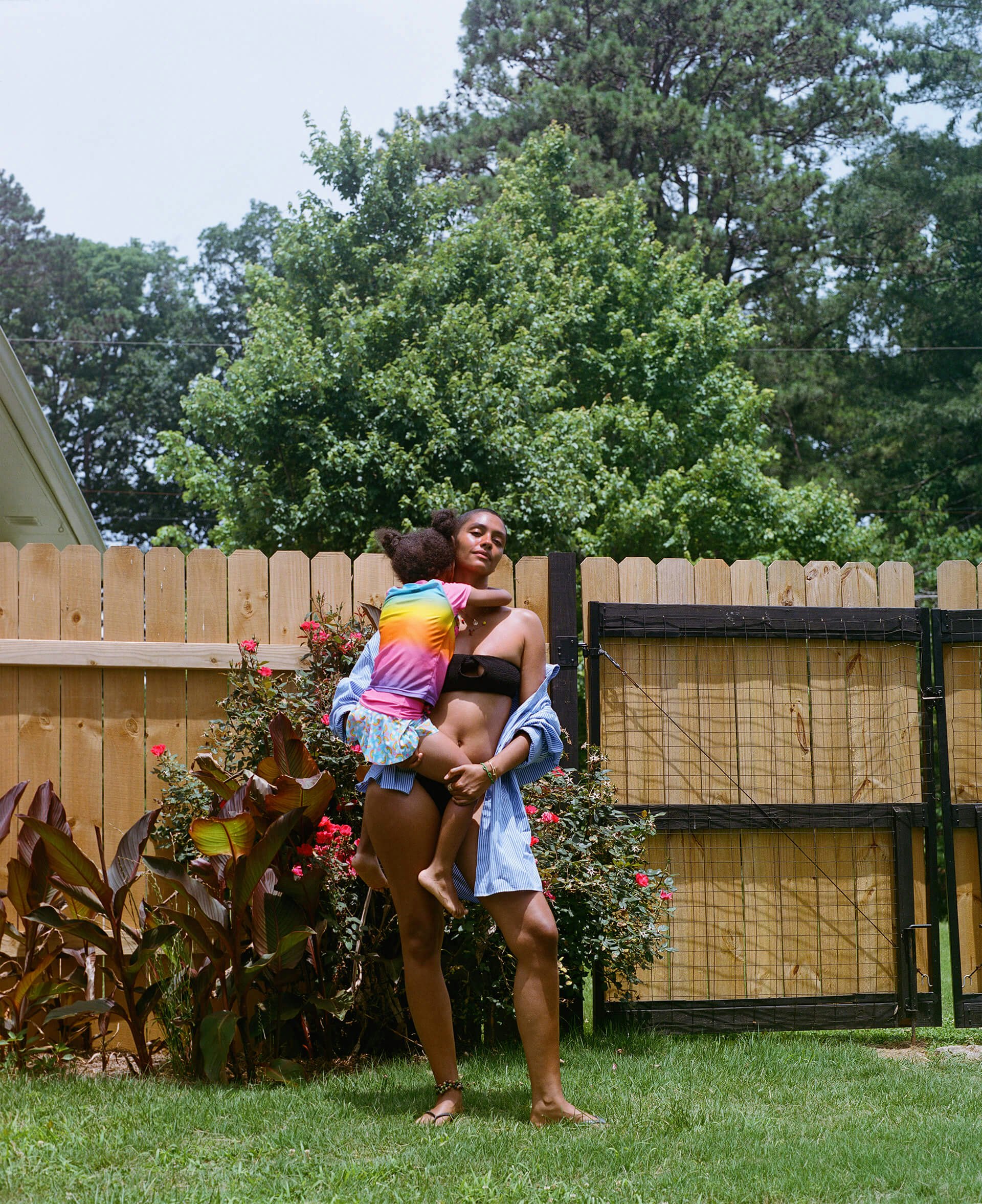 mom holding her daughter on the lawn