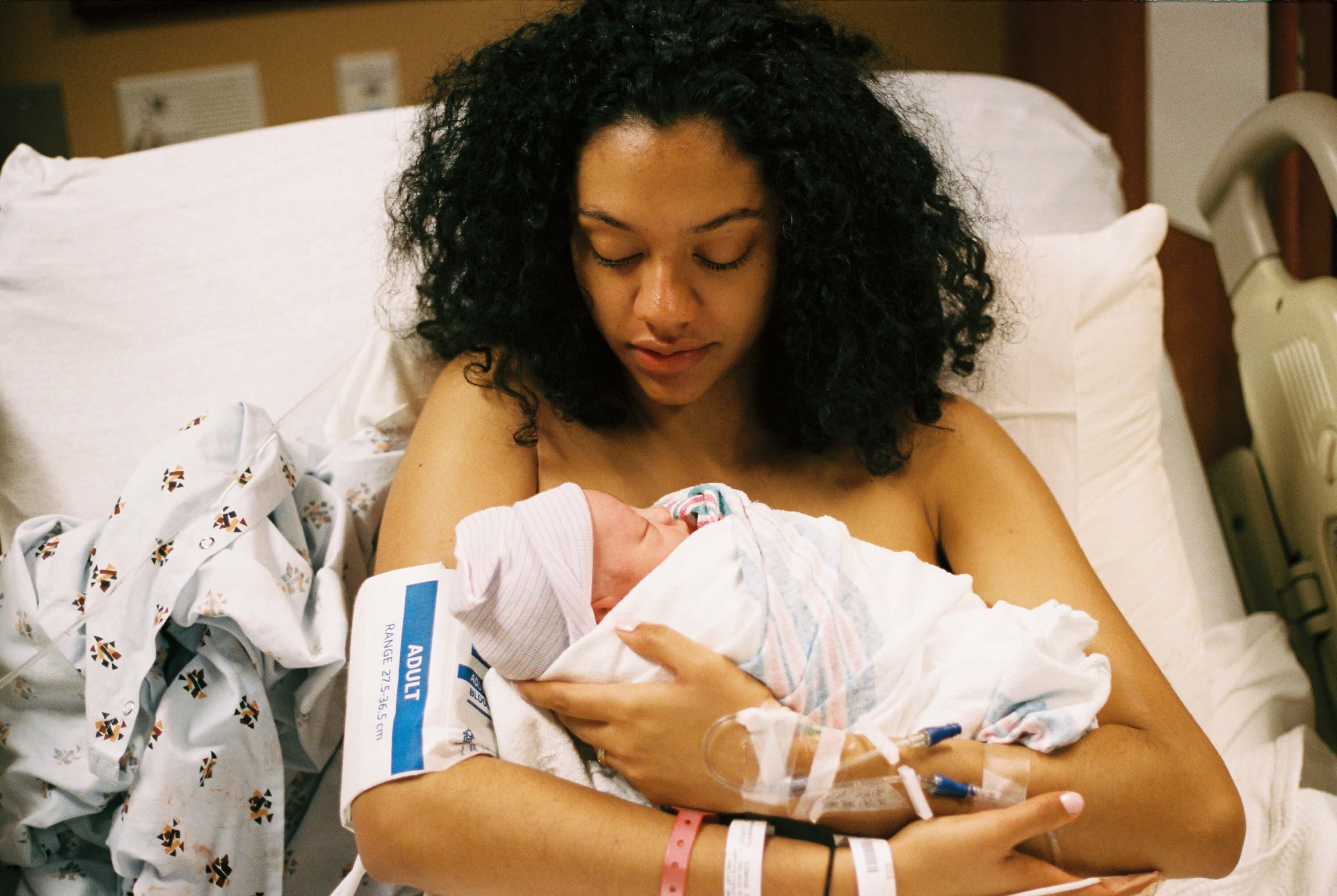 mom holding newborn baby in hospital