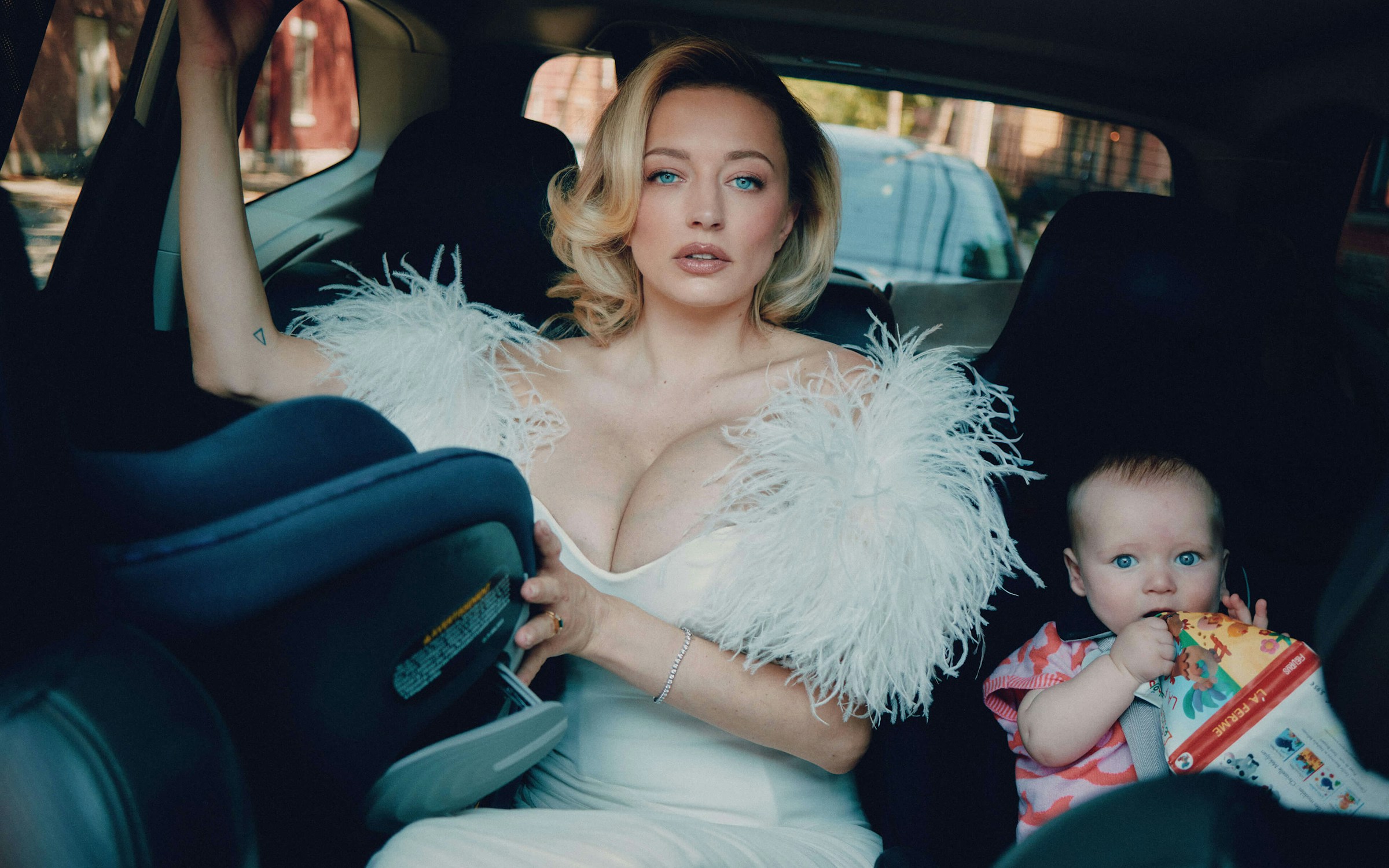 glamorous mom wearing a gown in the car with her baby