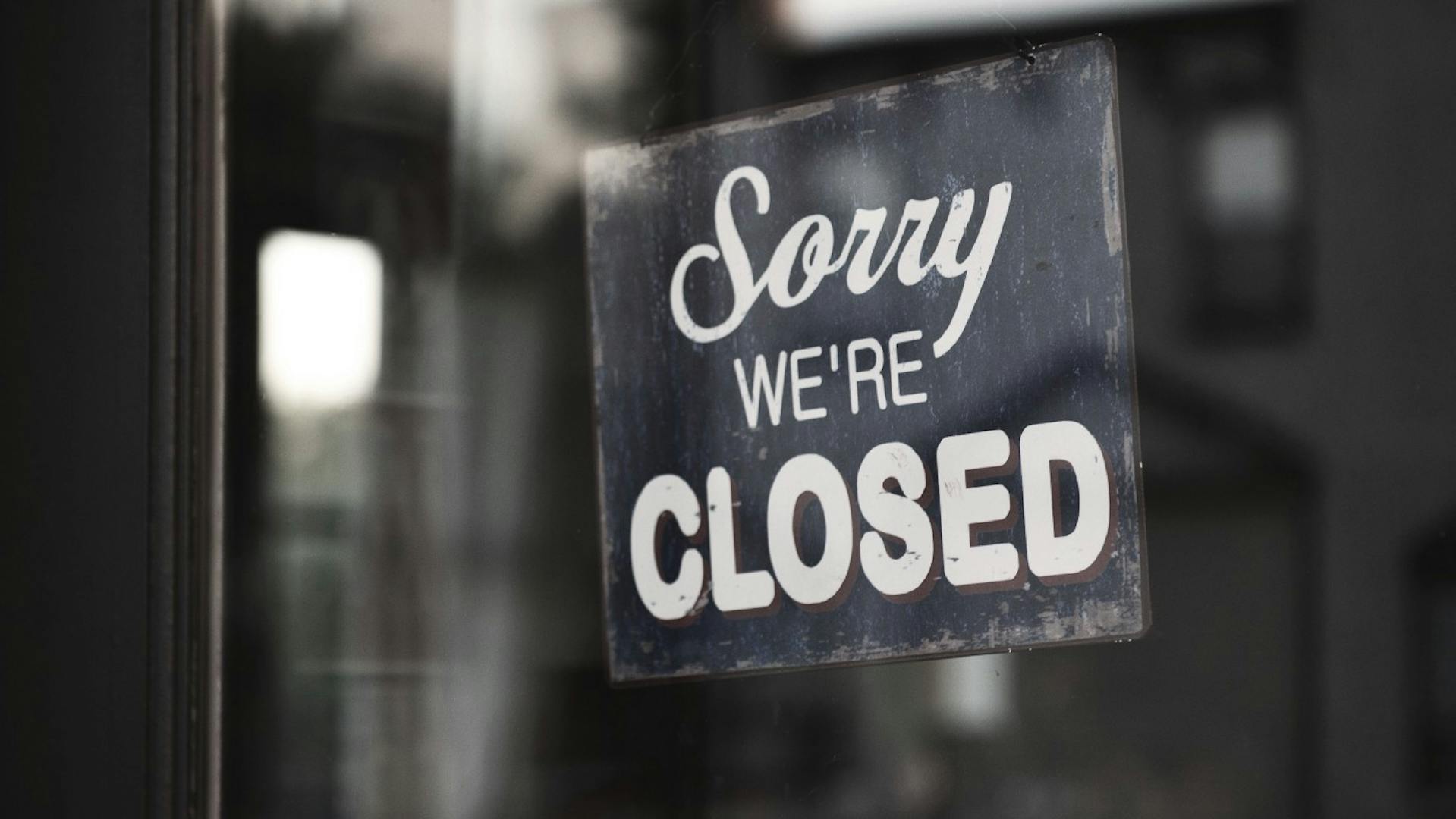 Small business with sorry we'e closed sign in the window