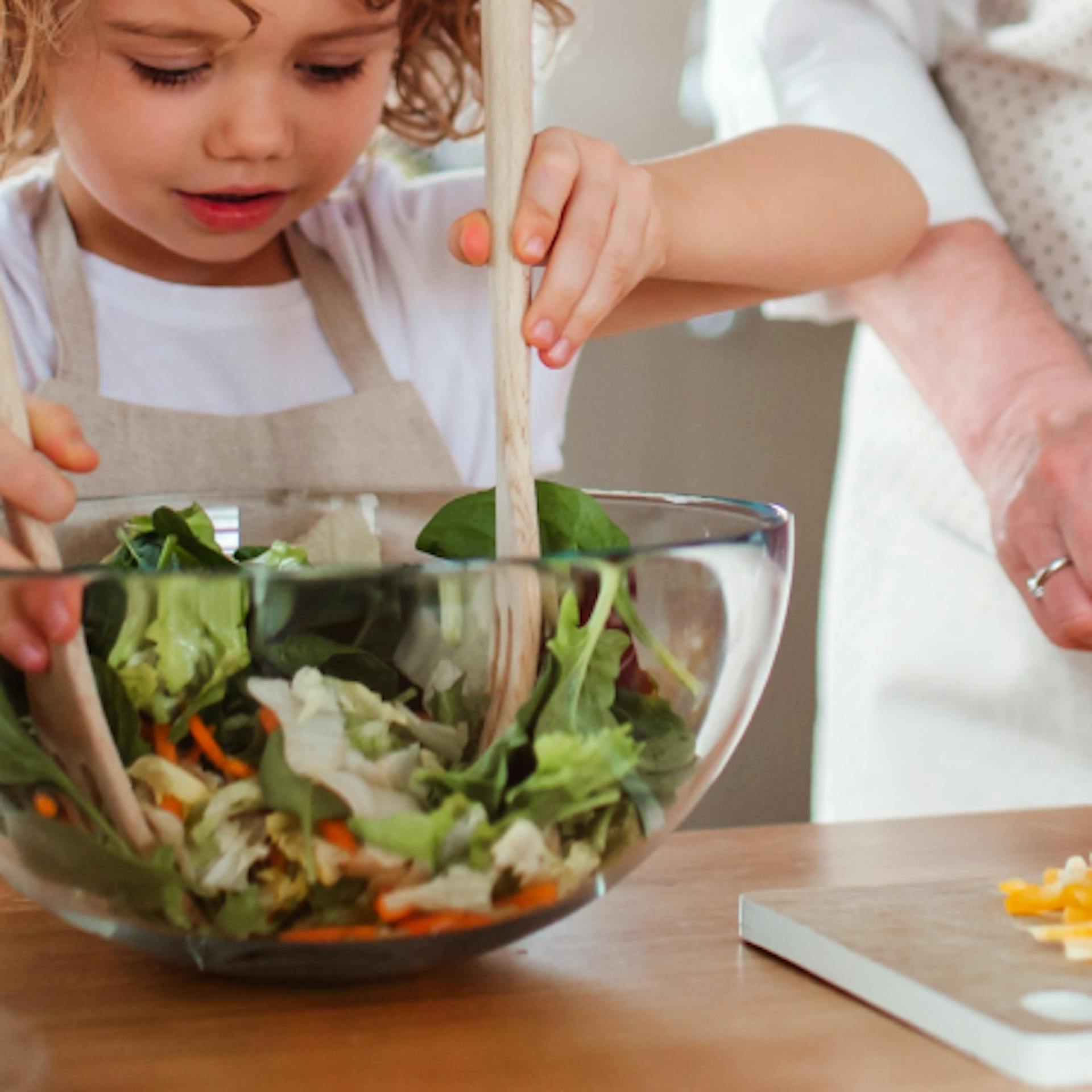 Young girl making salad