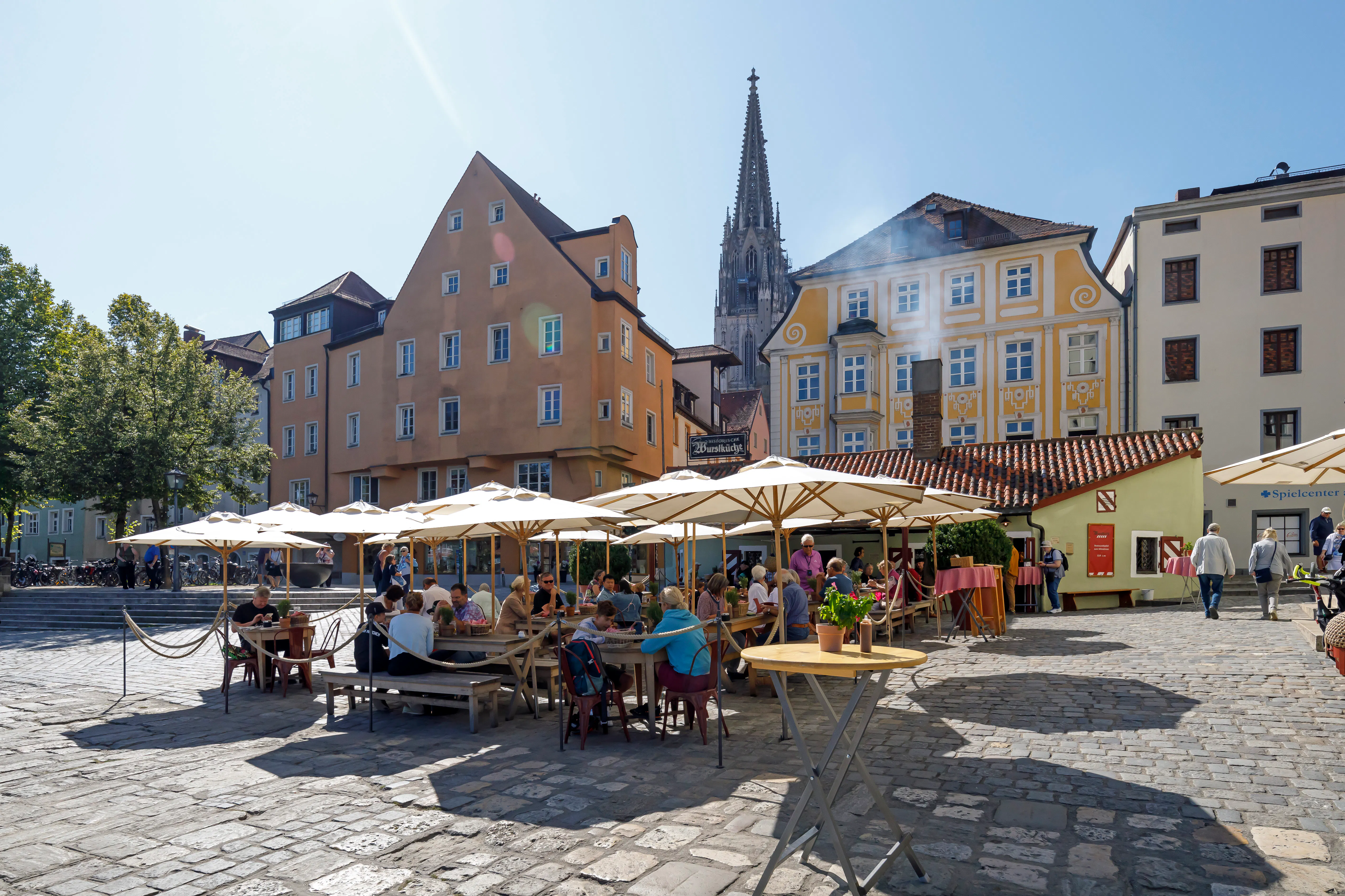 Historische Wurstkuchl am Donauufer mit Domspitzen im Hintergrund