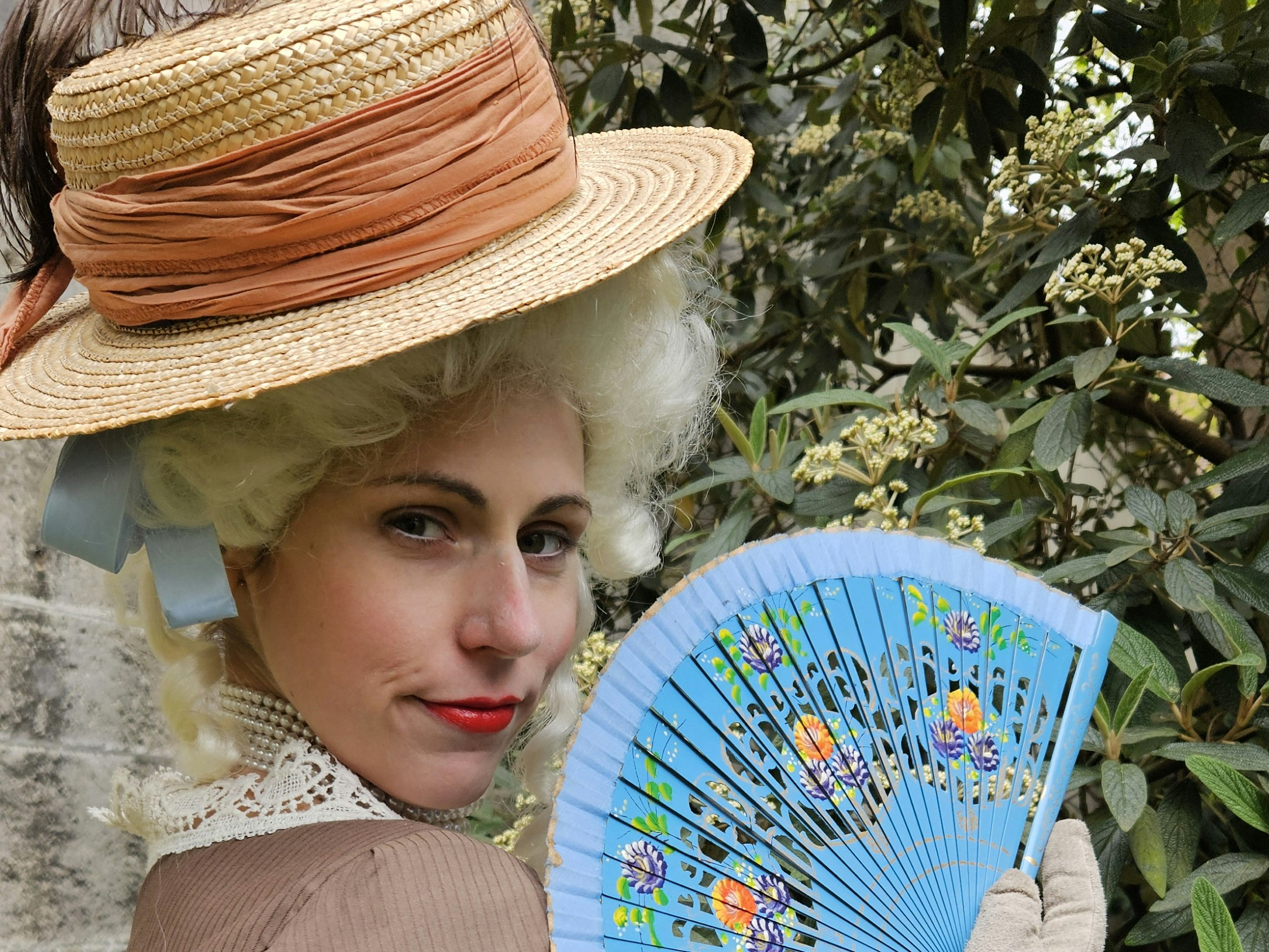 Schauspieler im Barockkostüm mit buntem Fächer in der Hand