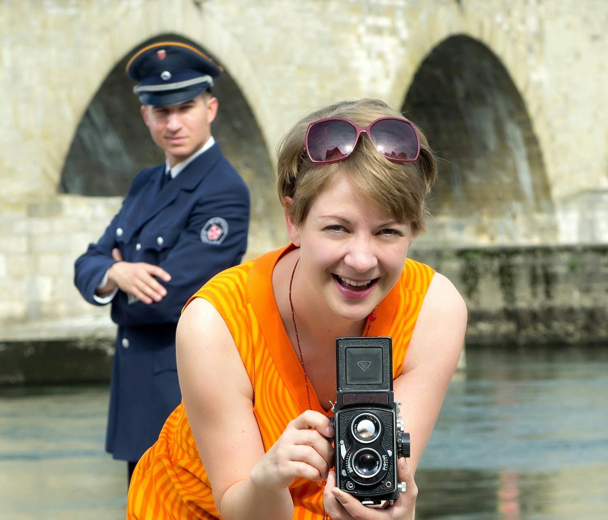 Zwei Darsteller aus der Führung, im Hintergrund ein Herr in Uniform, im Vordergrund eine Dame mit Kamera