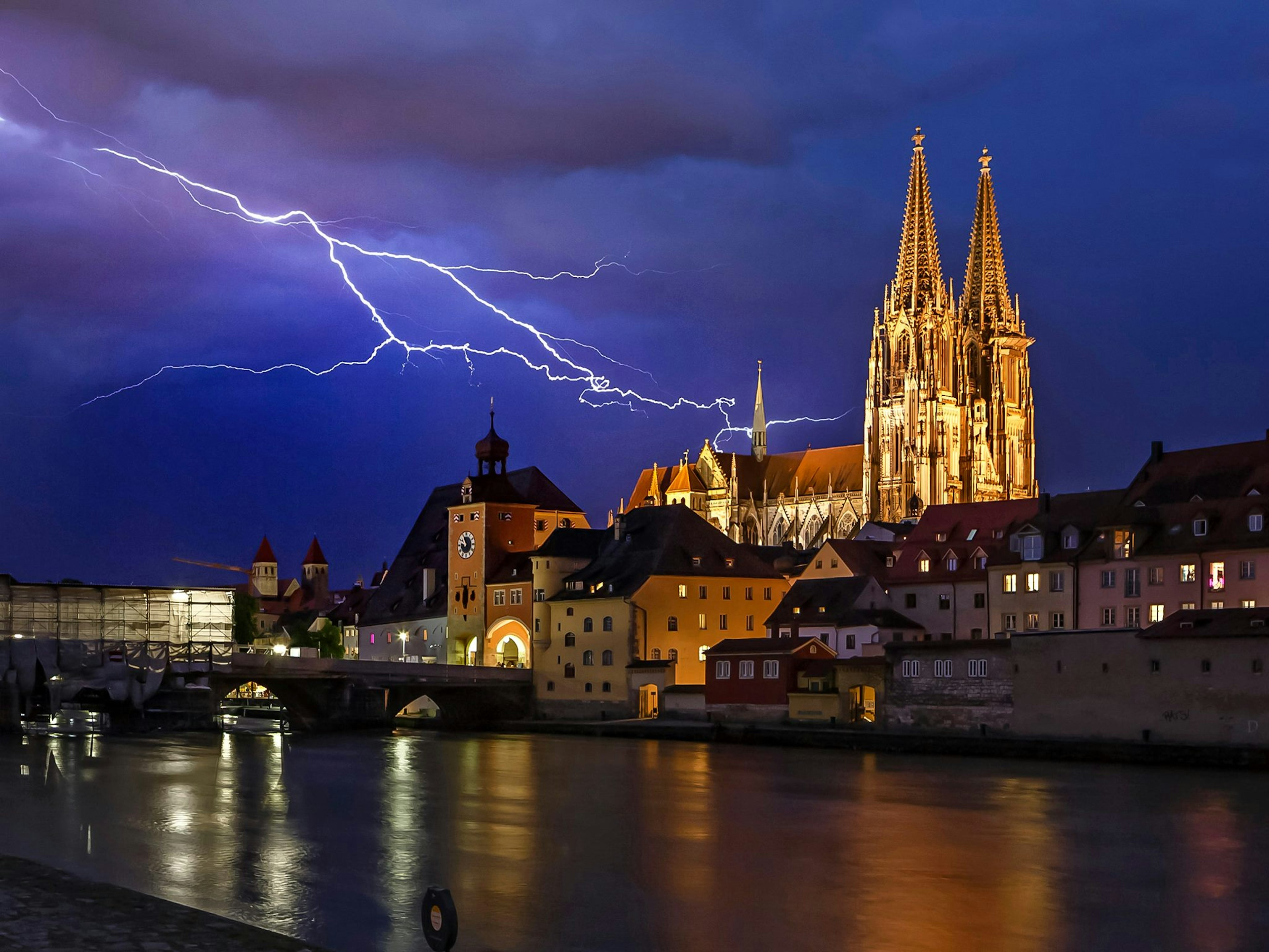 Skyline von Regensburg bei Nacht hell erleuchtet von einem Blitz