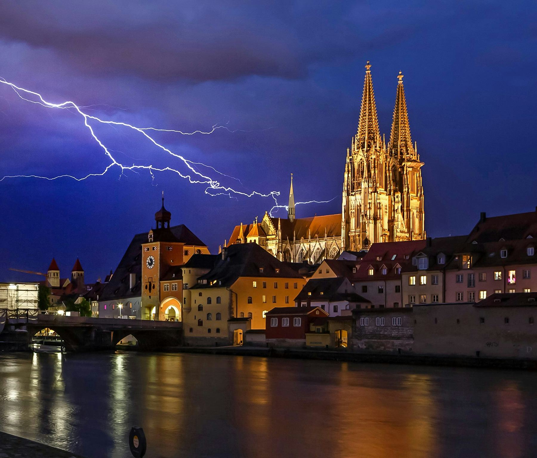 Skyline von Regensburg bei Nacht hell erleuchtet von einem Blitz