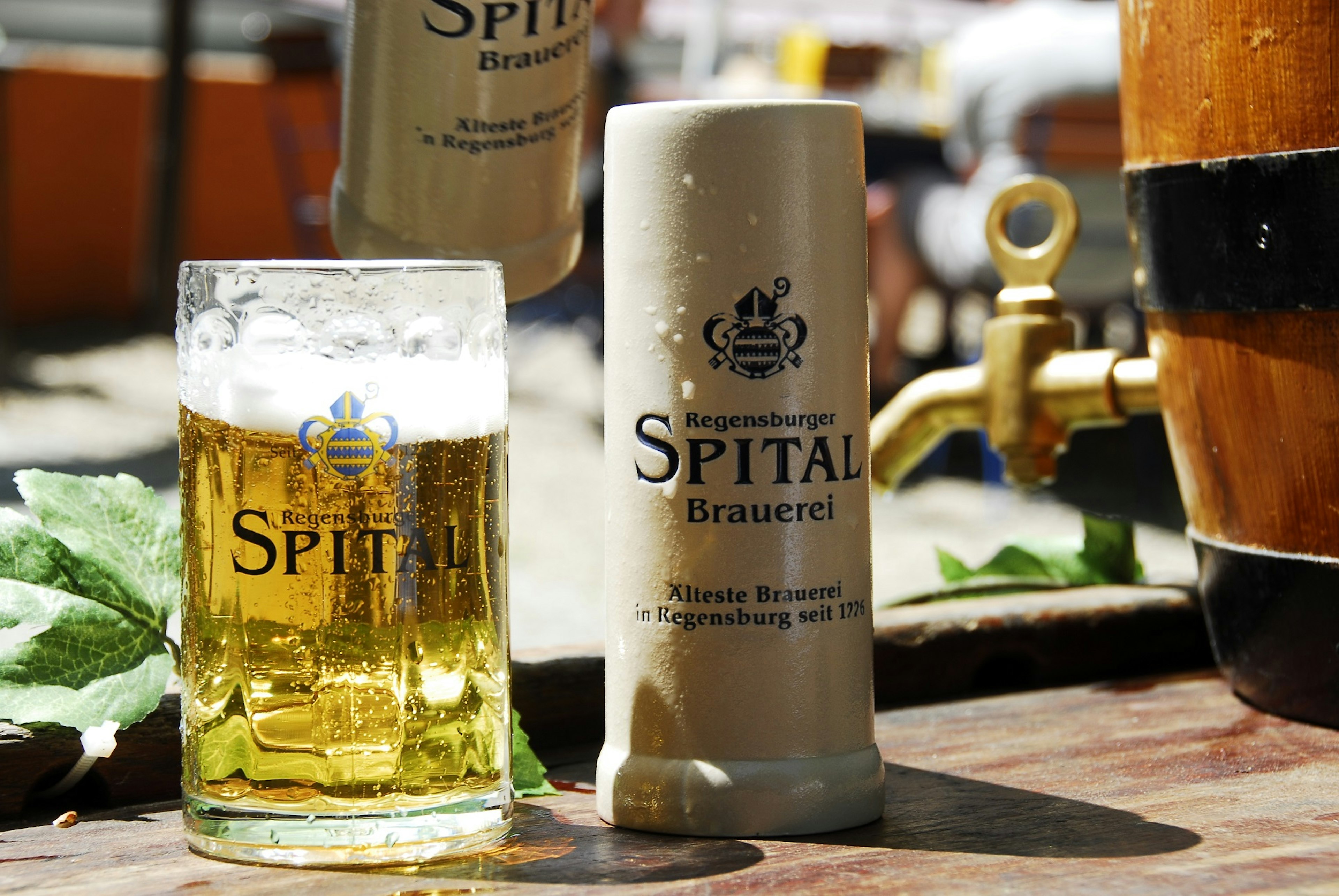 Bier im Glaskrug und im Steinkrug von der Spitalbrauerei auf einem Tisch