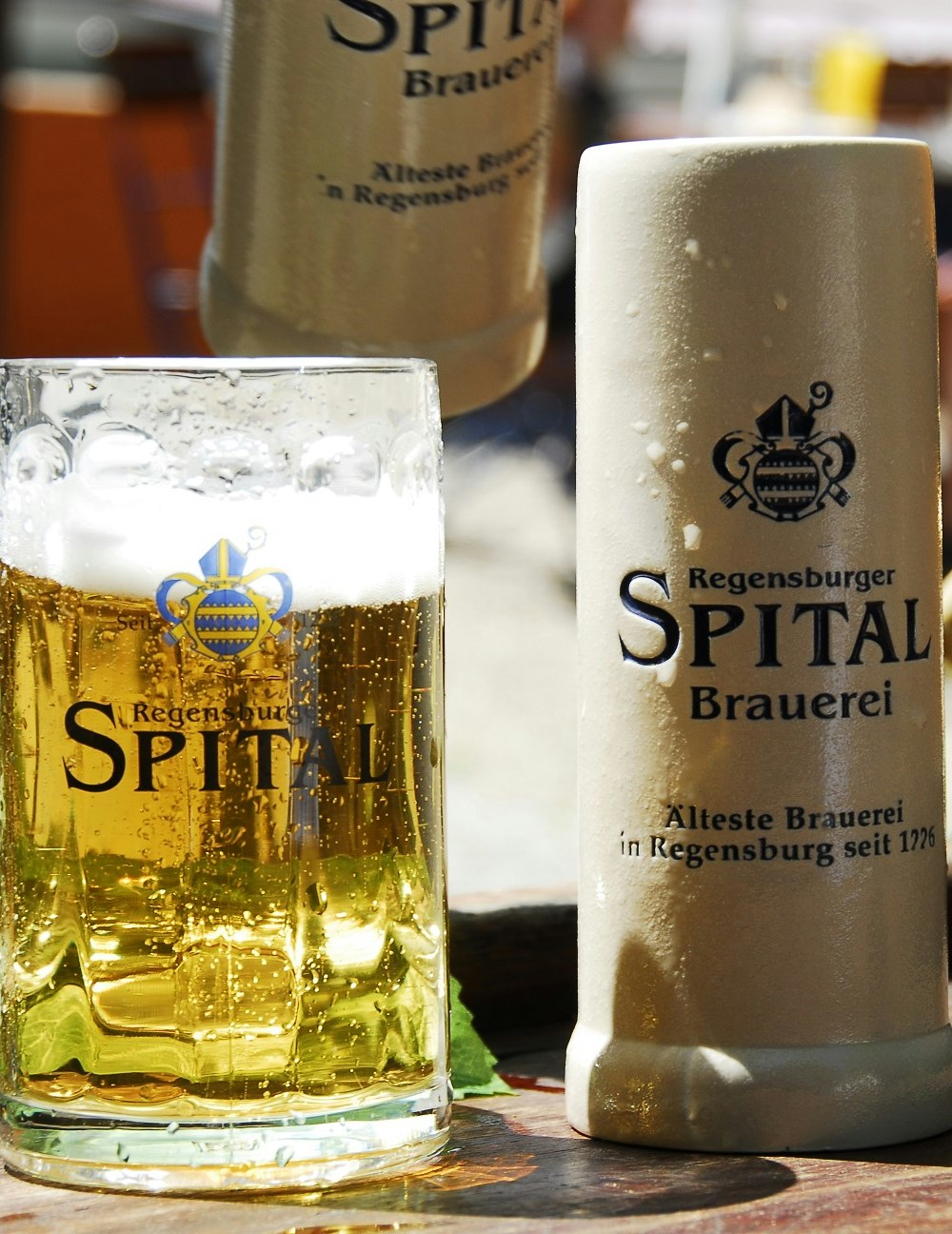 Bier im Glaskrug und im Steinkrug auf einem Tisch