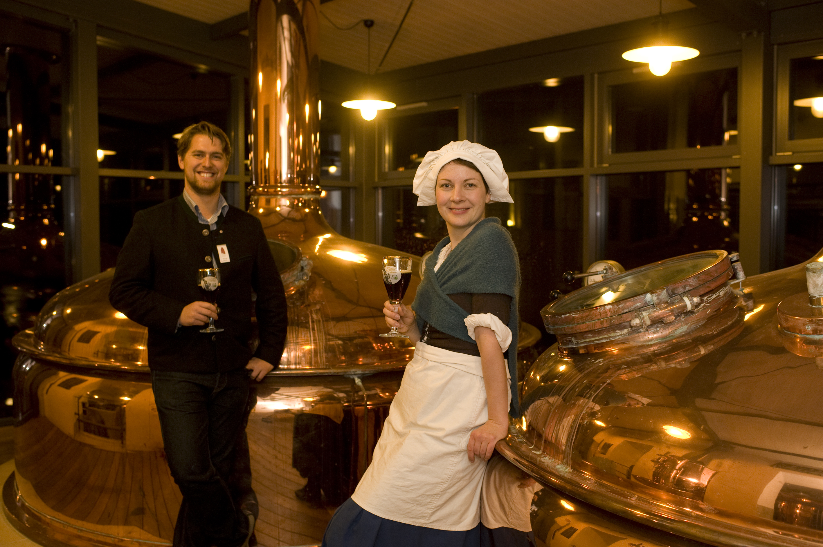 Moderator und Schauspielerin neben den riesigen Kesseln