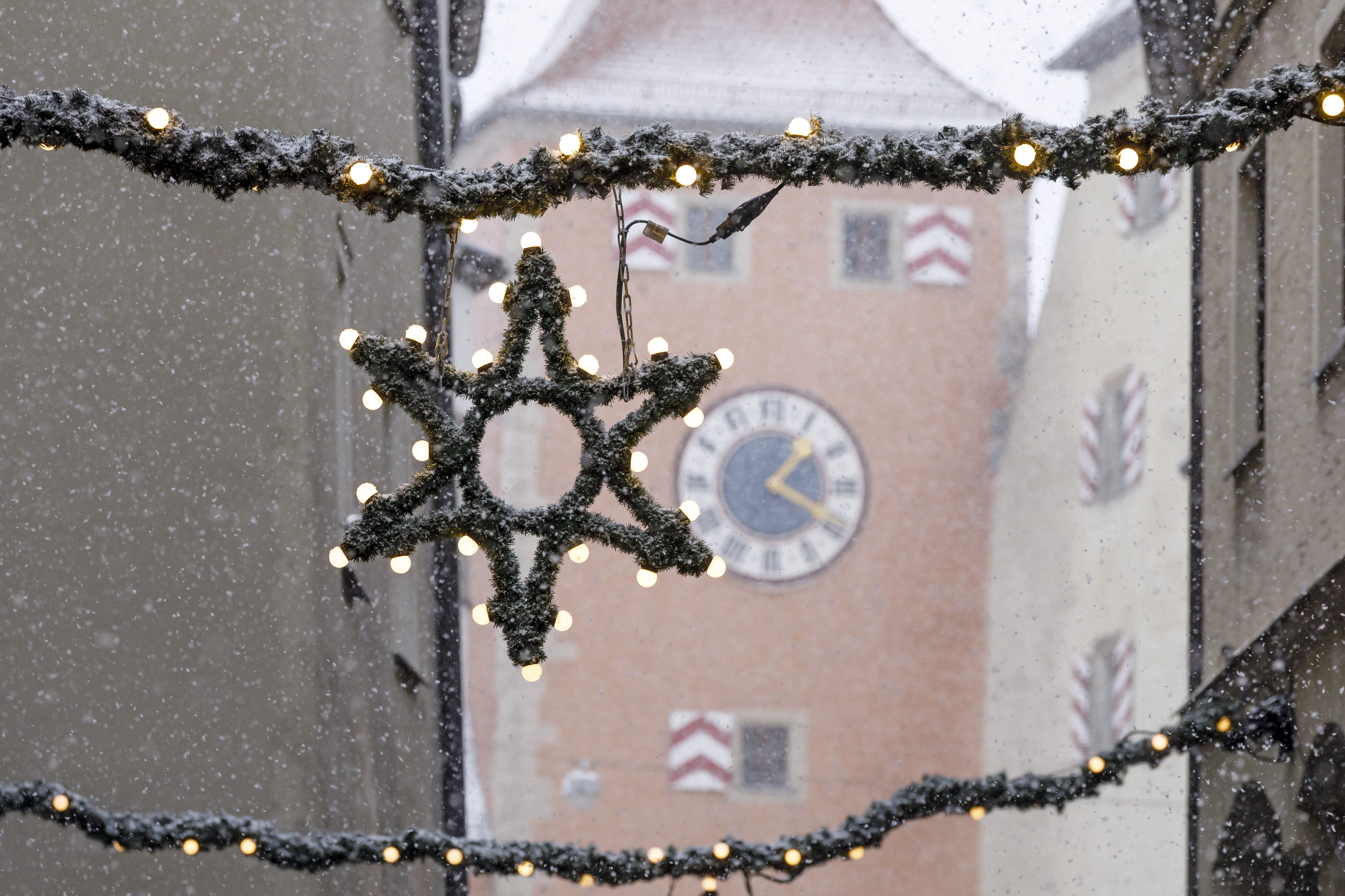 Weihnachtliche Deko in der Gasse bei Schneetreiben