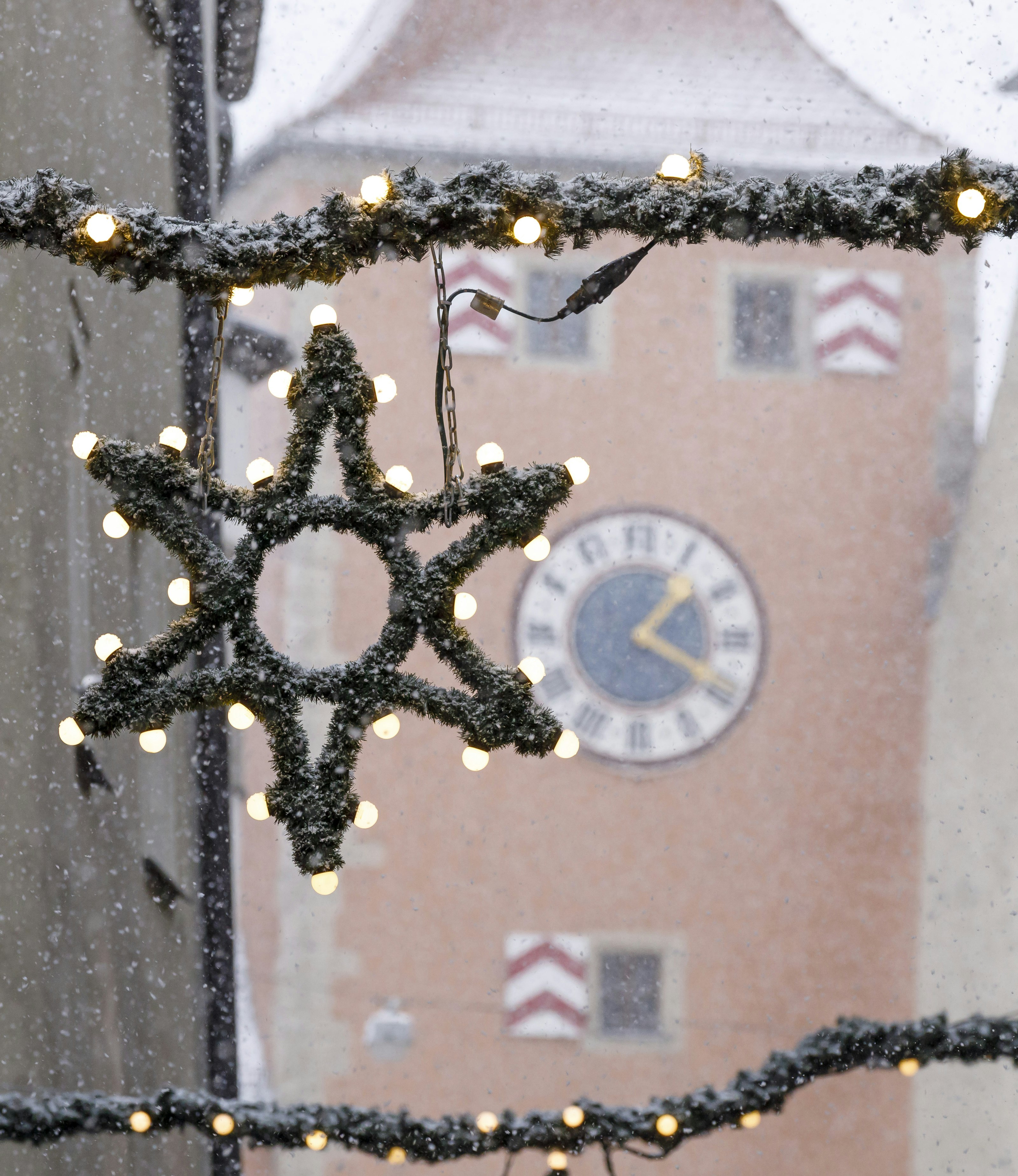 Weihnachtliche Deko in der Gasse bei Schneetreiben