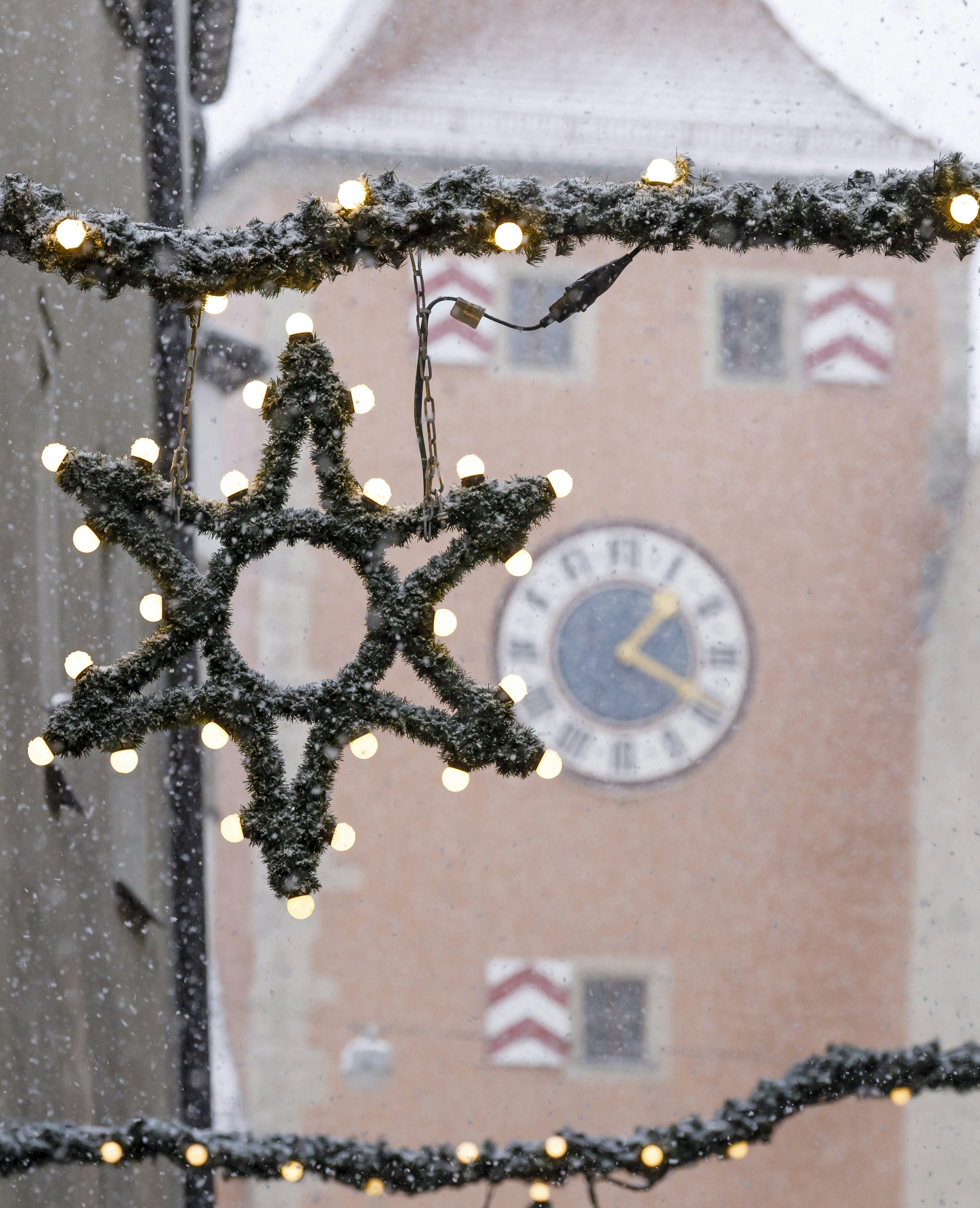 Weihnachtliche Deko in der Gasse bei Schneetreiben