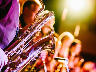 Saxophon im Vordergrund und andere Musiker verschwommen im Hintergrund