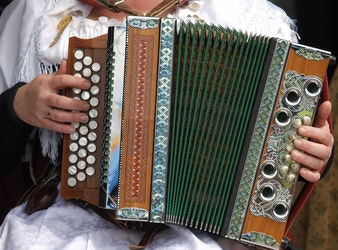 Frau mit Akkordeon auf dem Schoss.