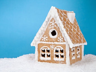 Lebkuchenhaus vor blauem Hintergrund im Schnee