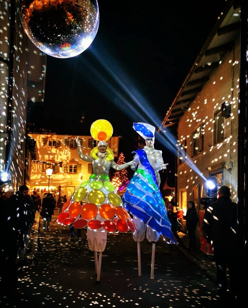 Stelzengeher in beleuchteten Kostümen