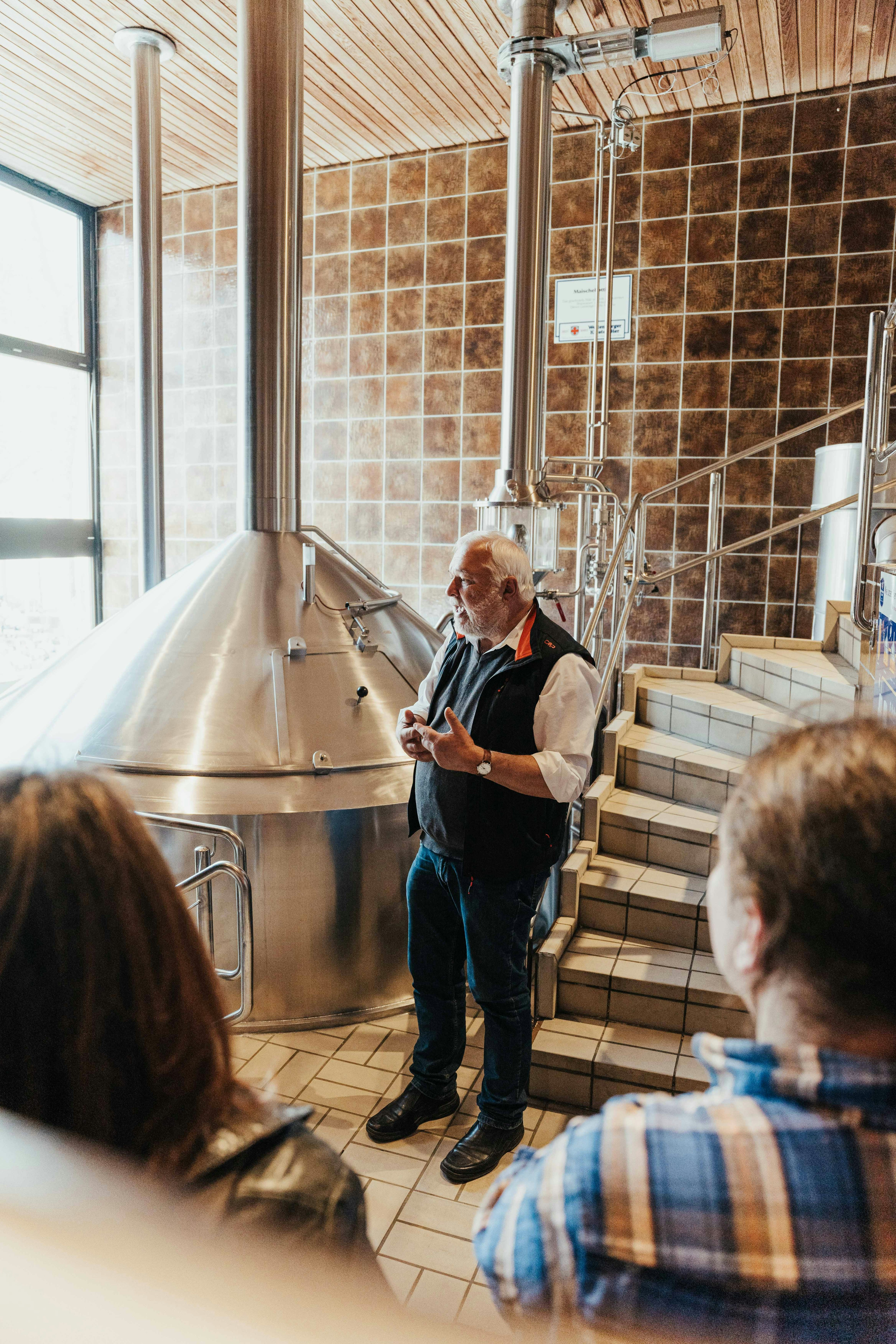 Der Guide in der Brauerei vor den Sudkesseln