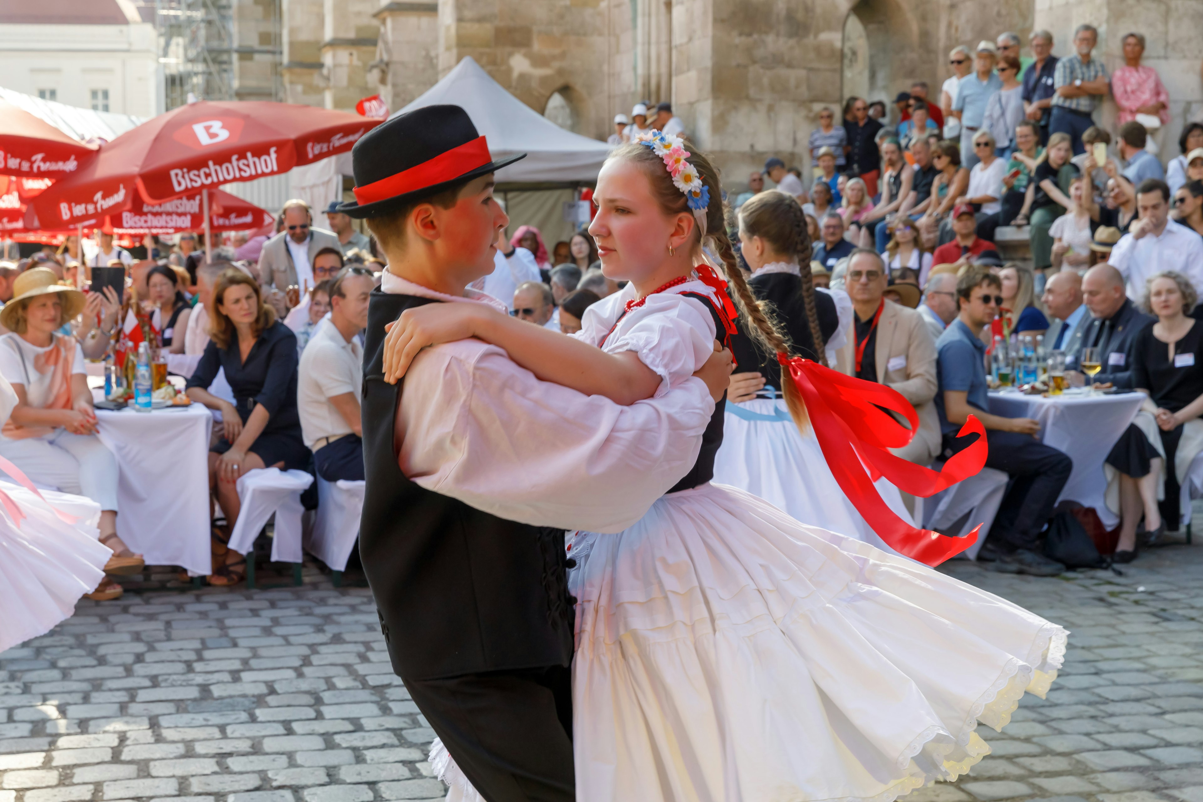 Zwei Kinder führen am Domplatz einen Tanz vor