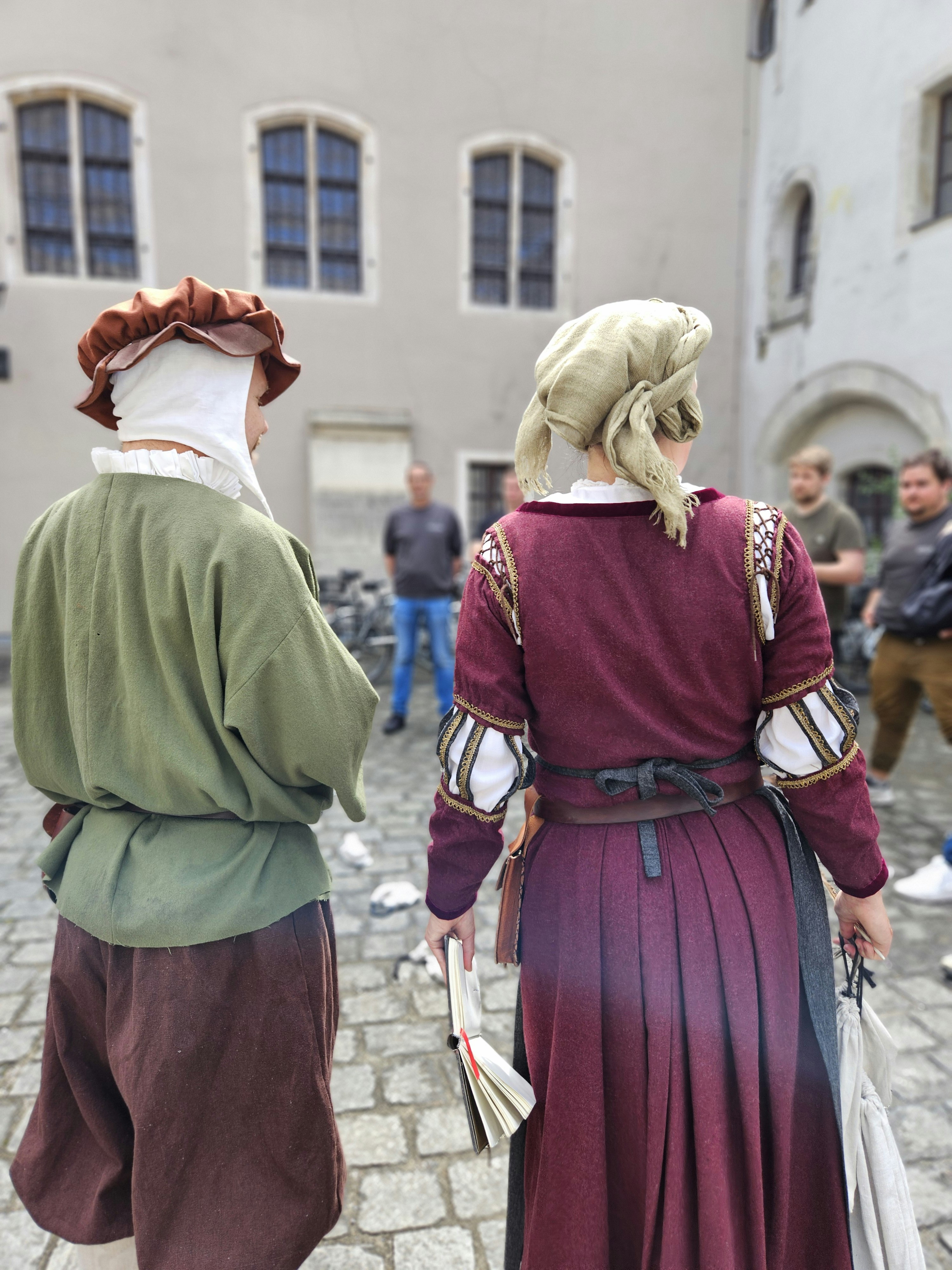 Zwei Schauspieler von hinten bei der Schnitzeljagd vor den Teilnehmern