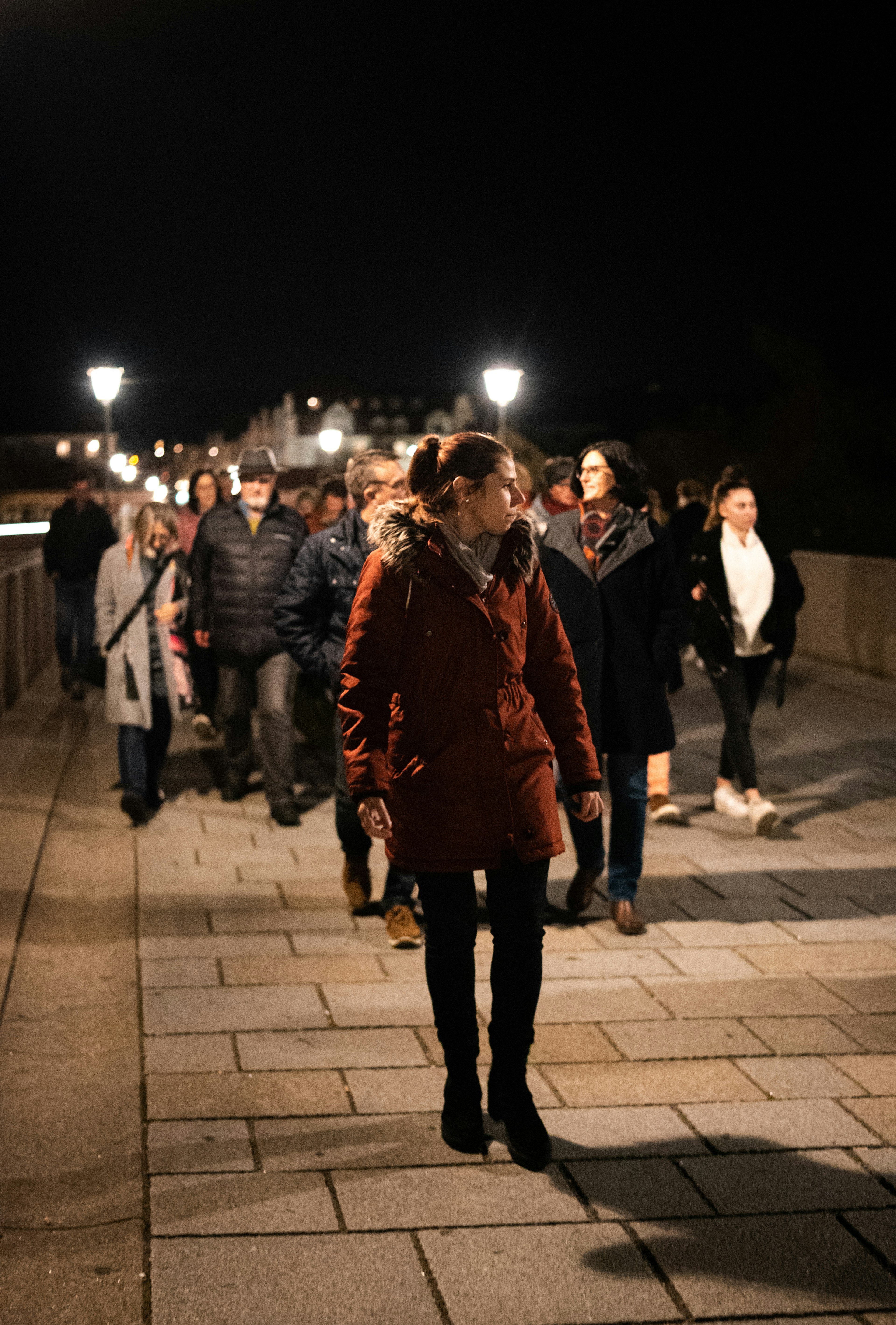 Guide mit der Gruppe geht über die steinerne Brücke