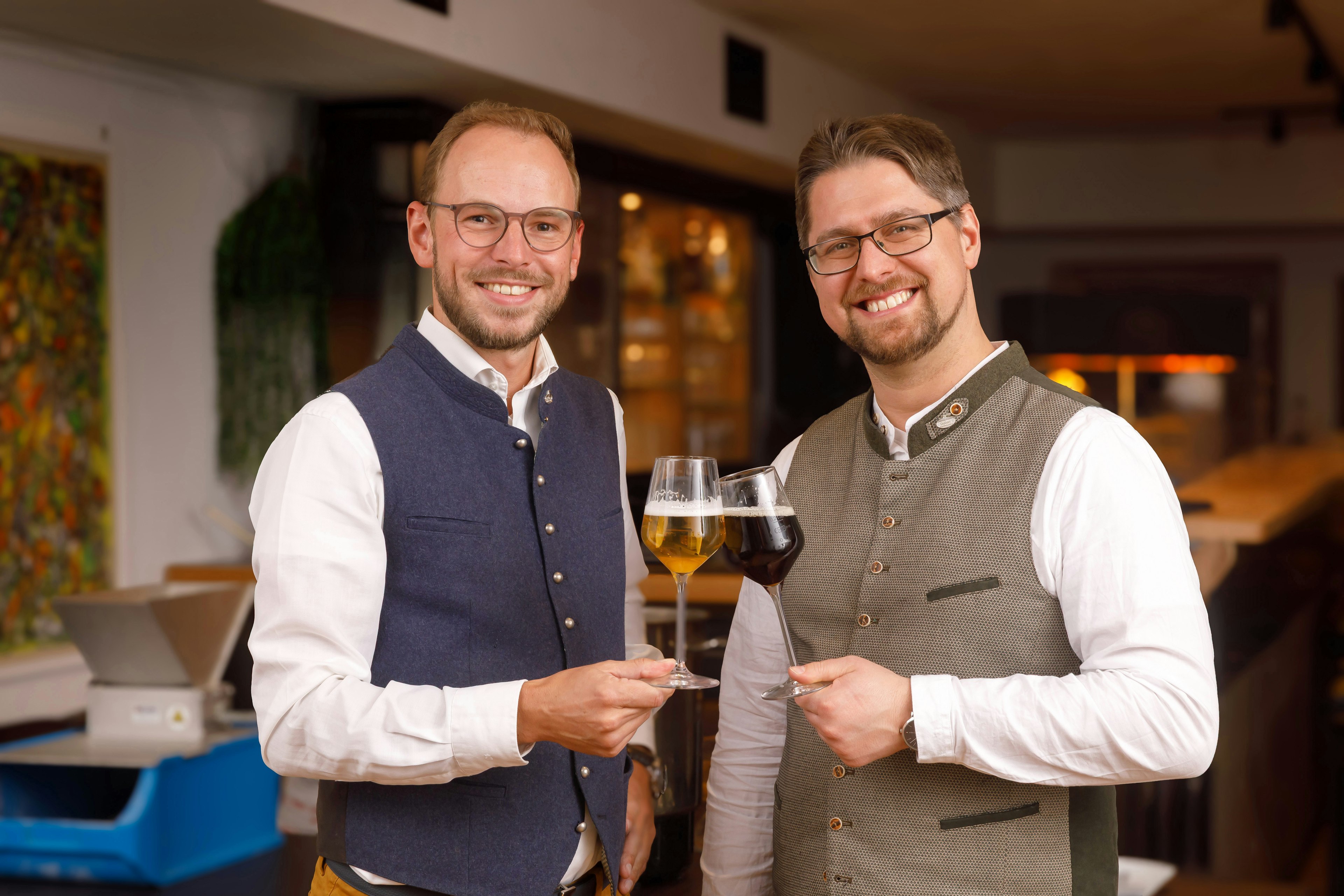 Die beiden Biersommeliers des Brauseminars stoßen mit einem Bier an 
