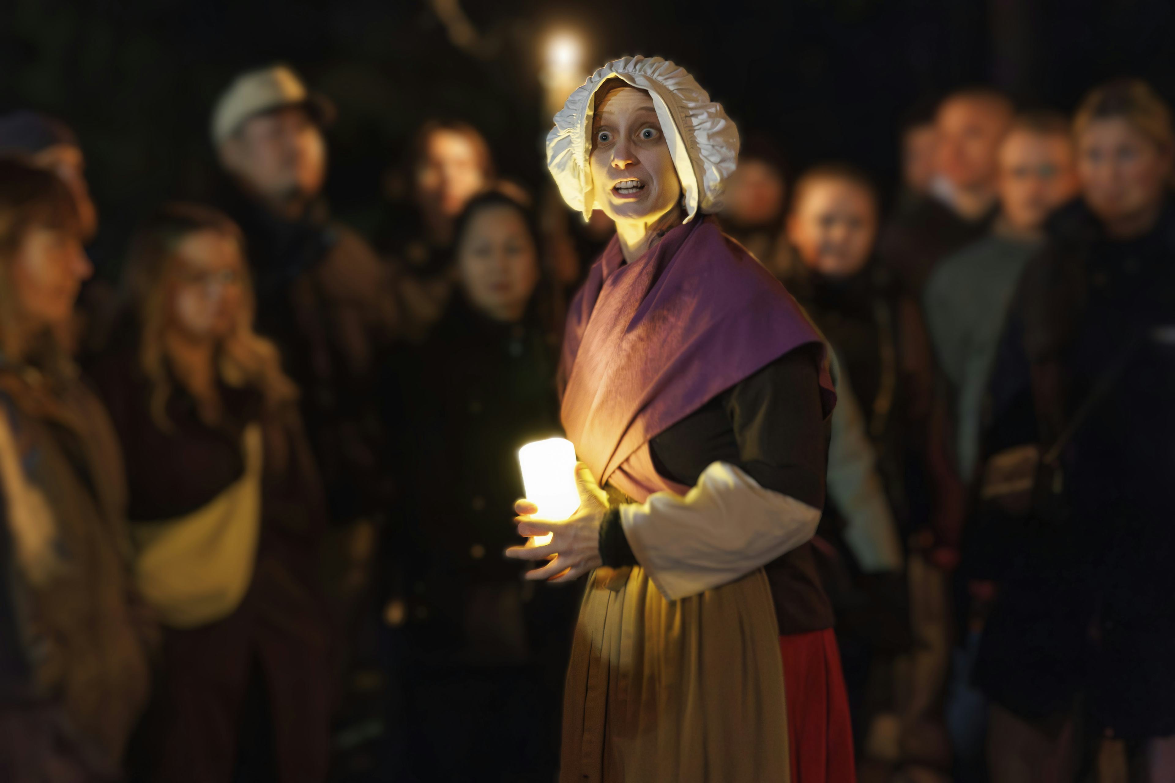 Darstellerin aus der Führung vor den Gästen im Hintergrund