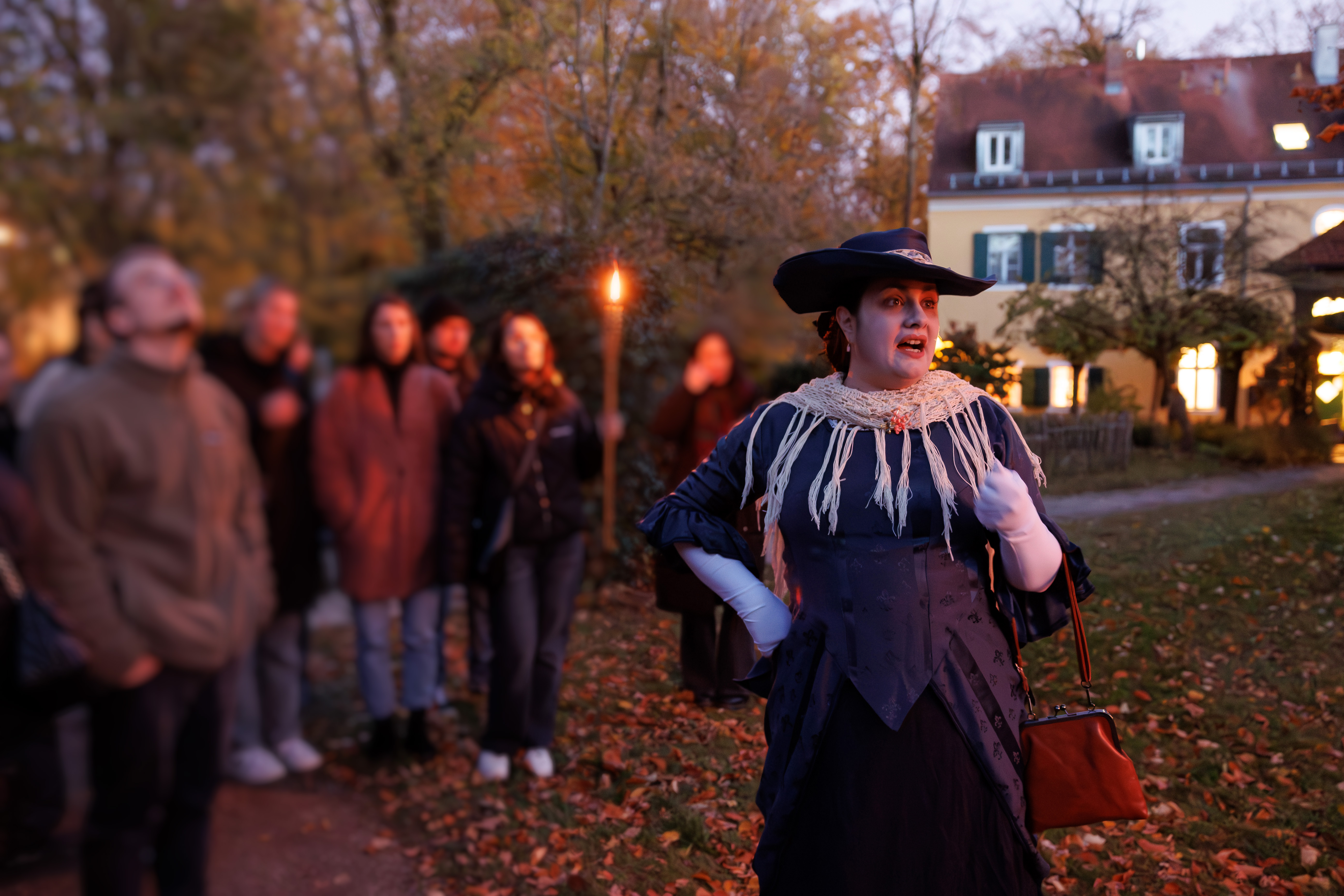 Darstellerin, die die Gruppe durch die Führung begleitet