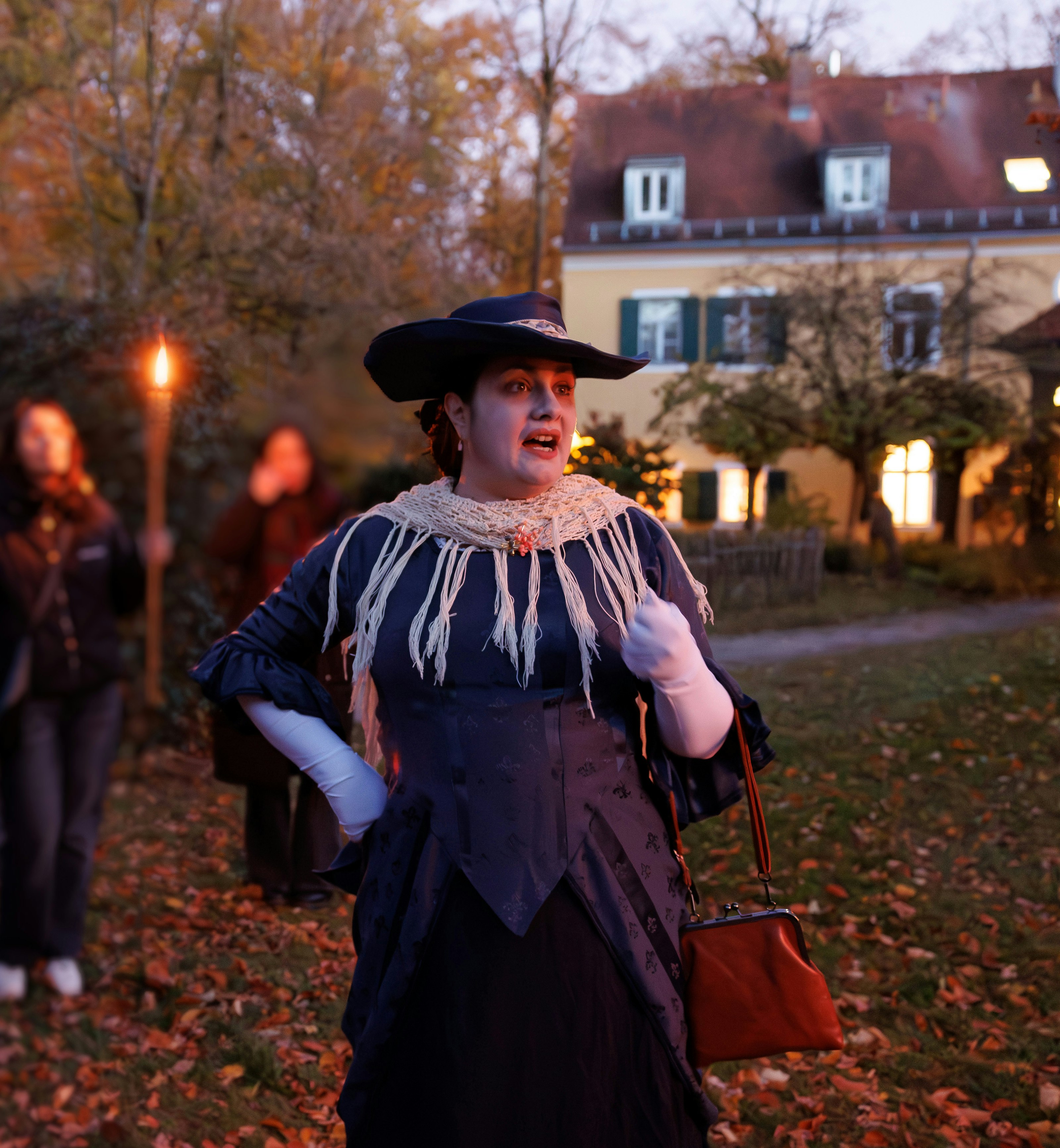 Darstellerin, die die Gruppe durch die Führung begleitet