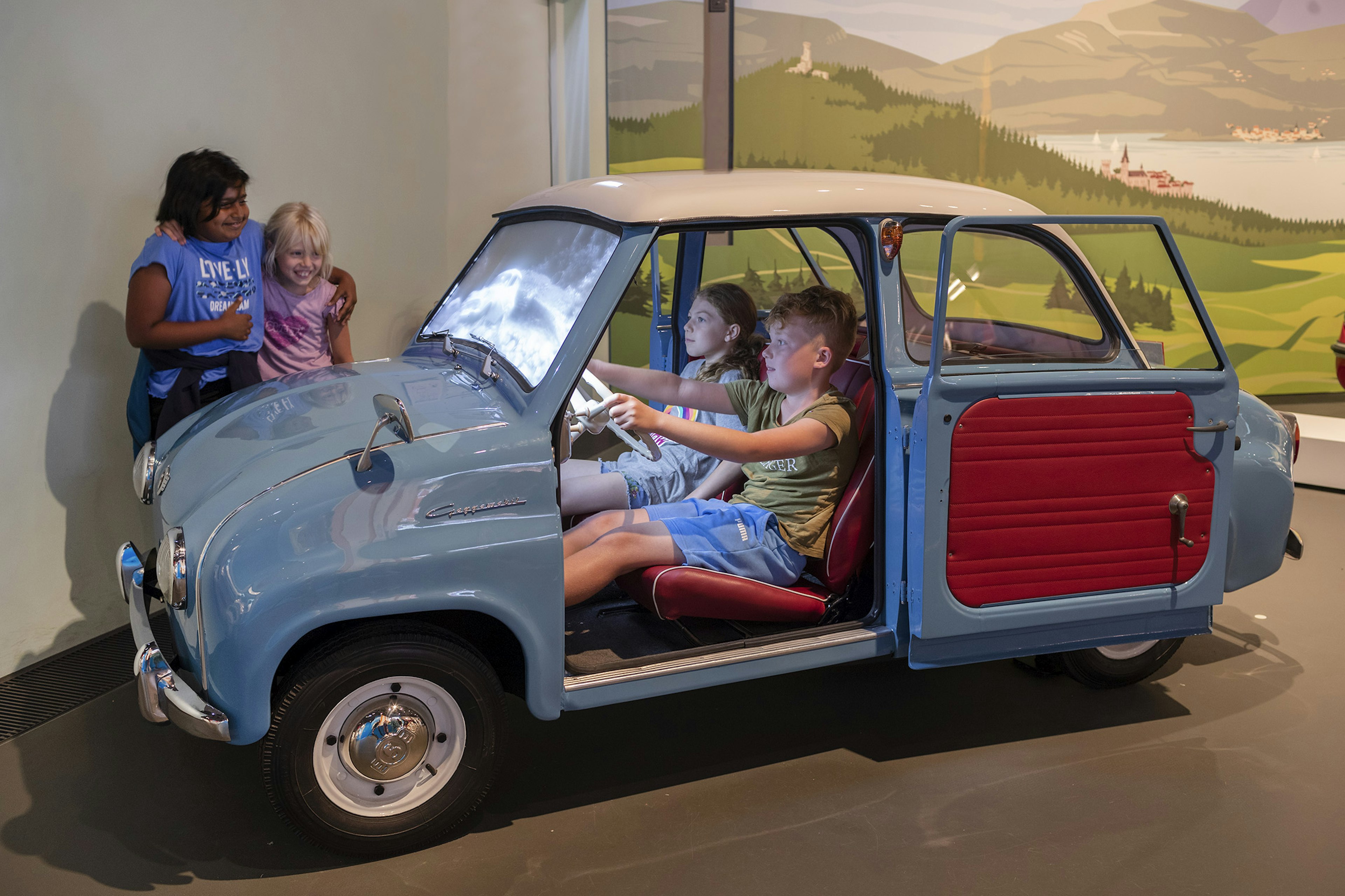 Kinder an interaktivem Ausstellungsstück (altes Auto) in der Dauerausstellung im Haus der Bayerischen Geschichte