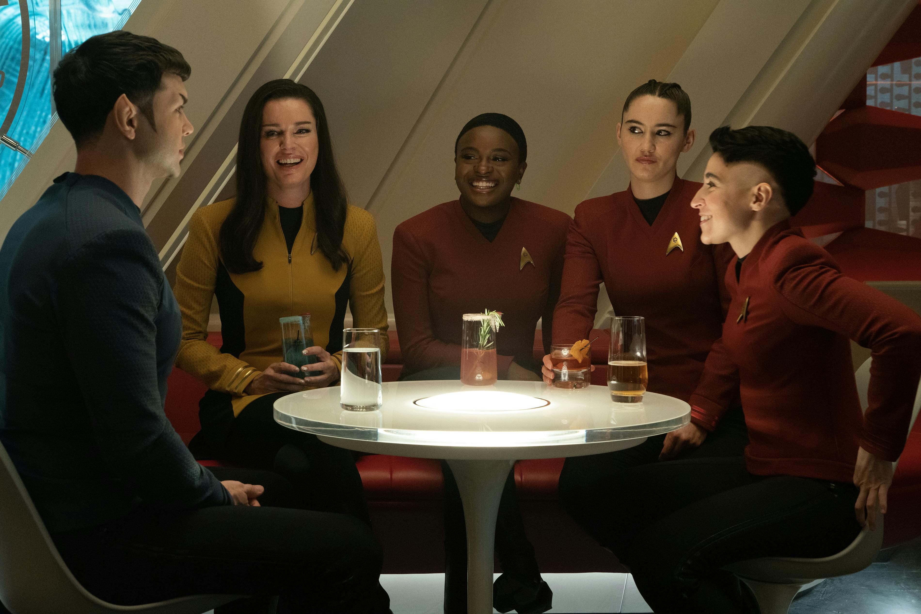 Spock sits in the Enterprise lounge while his friends Number One (Una), Uhura, La'An, and Erica Ortegas are enjoying his company in 'Charades'