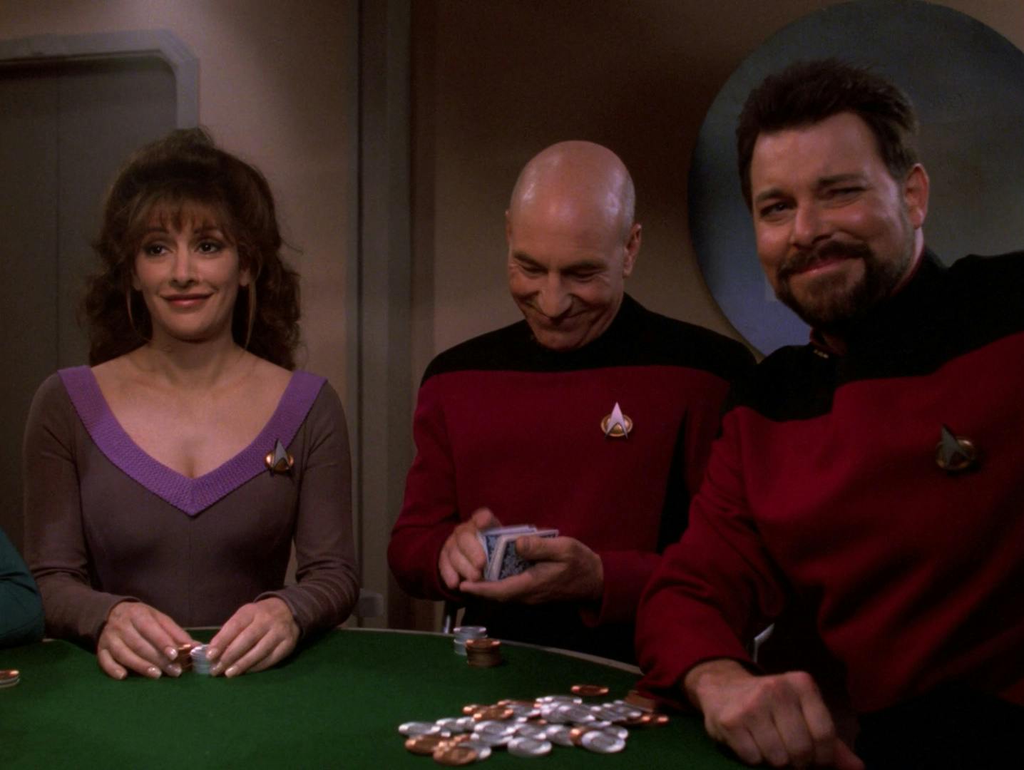 Picard joins his first crew poker game, shuffling the deck as he smiles to himself, as Deanna Troi and Riker look at the others at the table in 'All Good Things...'