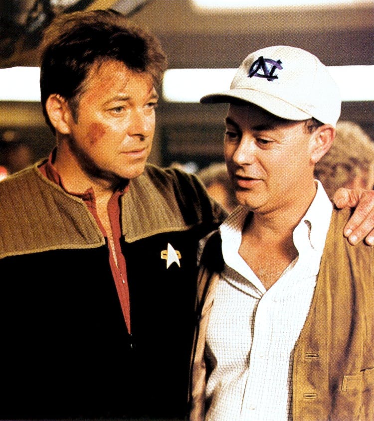 Jonathan Frakes with his arm around Michael Piller's shoulder behind-the-scenes on set of Star Trek: Insurrection