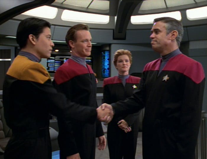 Captain Janeway introduces Tom Paris and Harry Kim to First Officer Cavit who shakes hands with Kim on the bridge of Voyager in 'Caretaker'